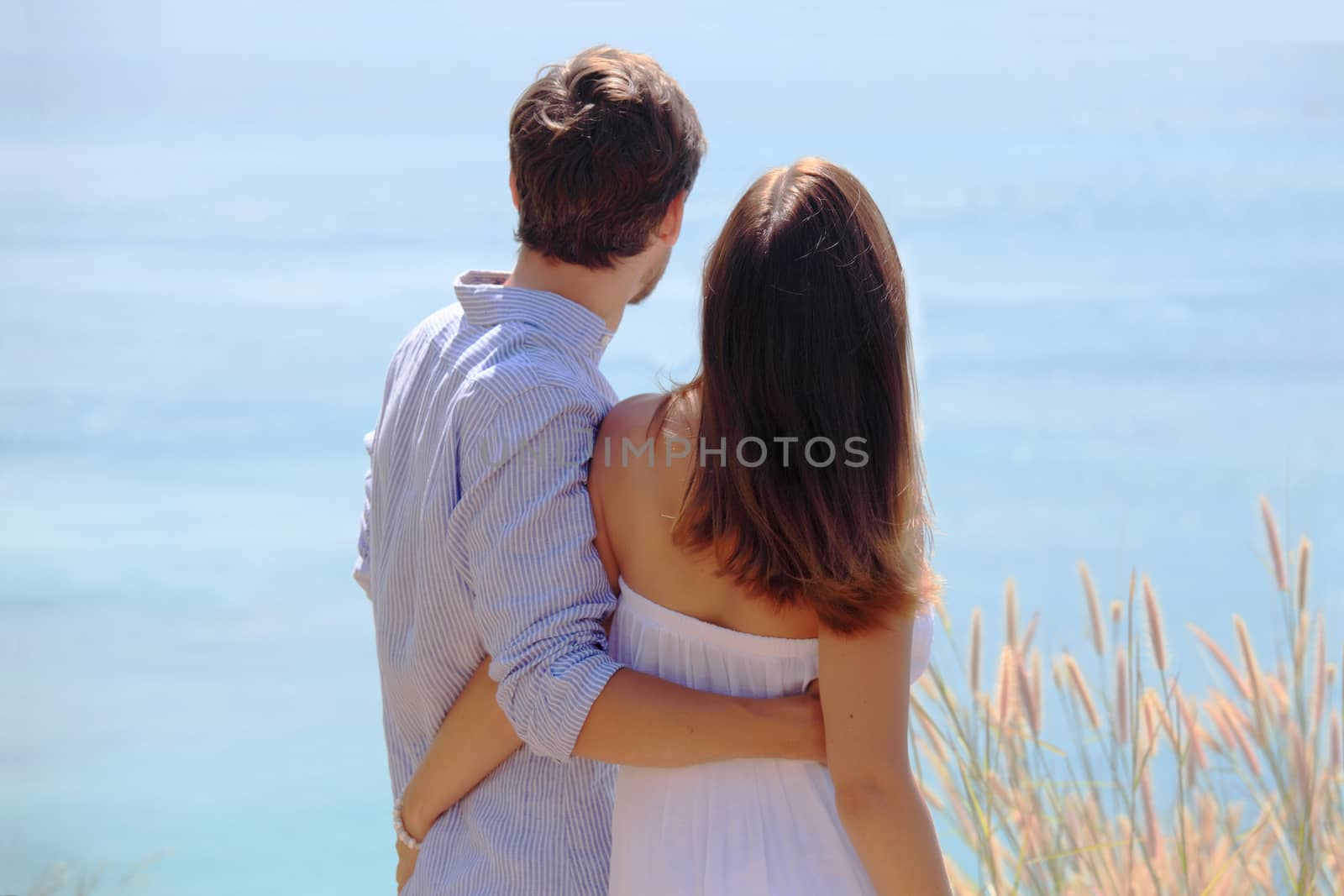 Young couple on vacation looking at sea together