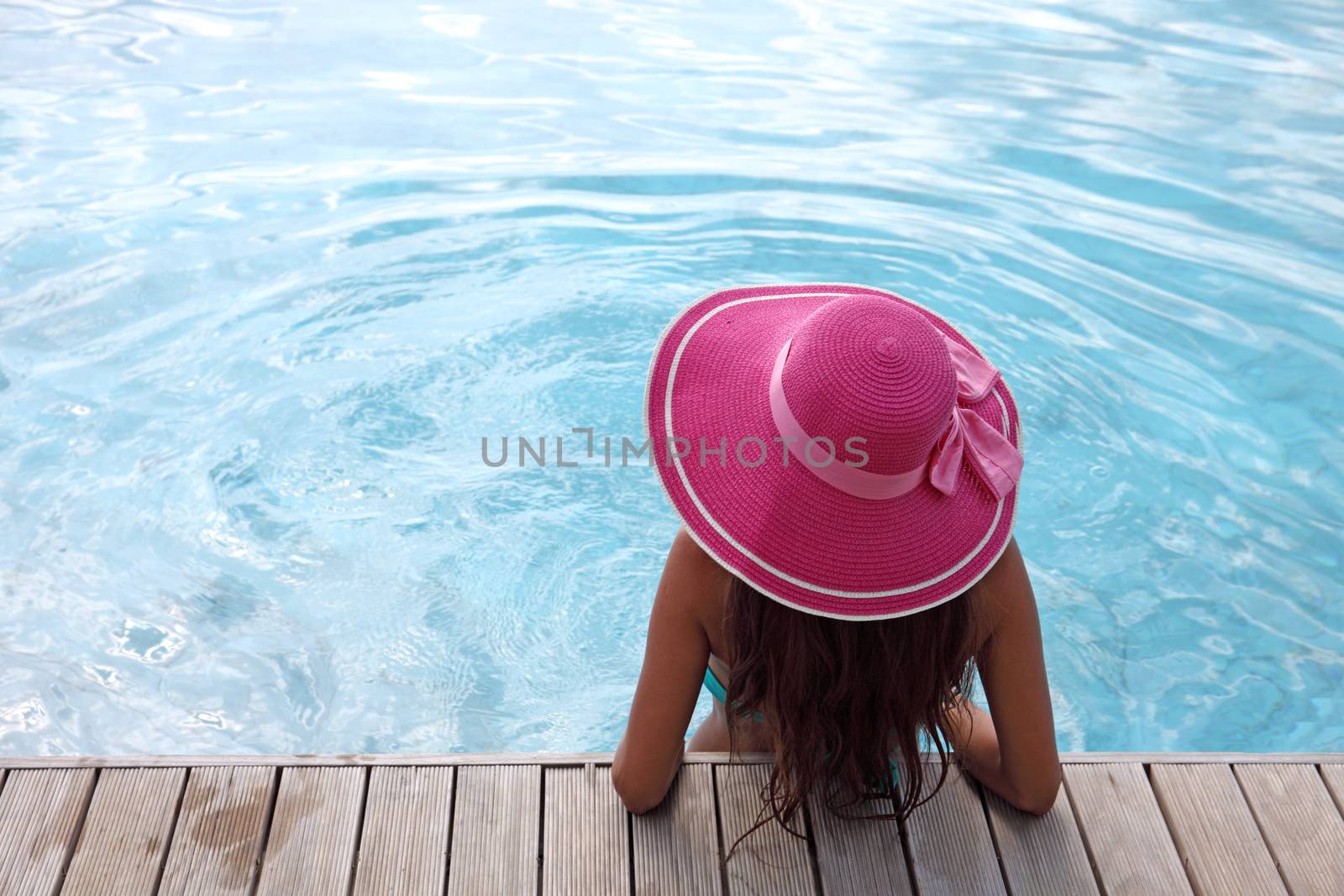 Beautiful woman relaxing at swimming pool at tourist resort