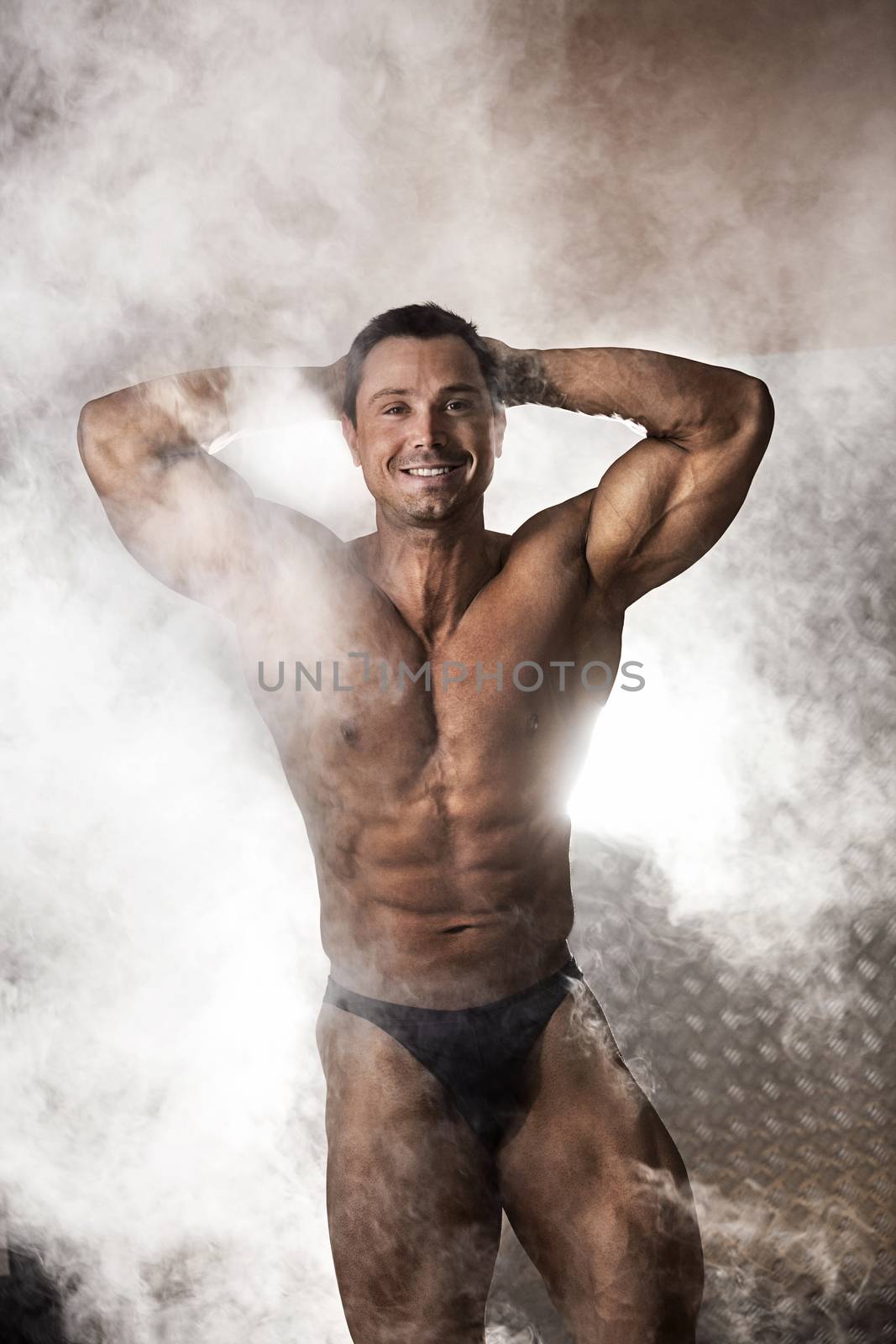 Portrait of male bodybuilder surrounded with smoke