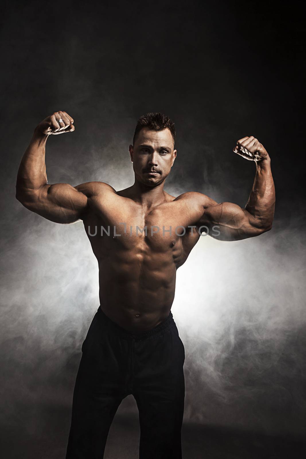 Portrait of muscular man flexing his muscles