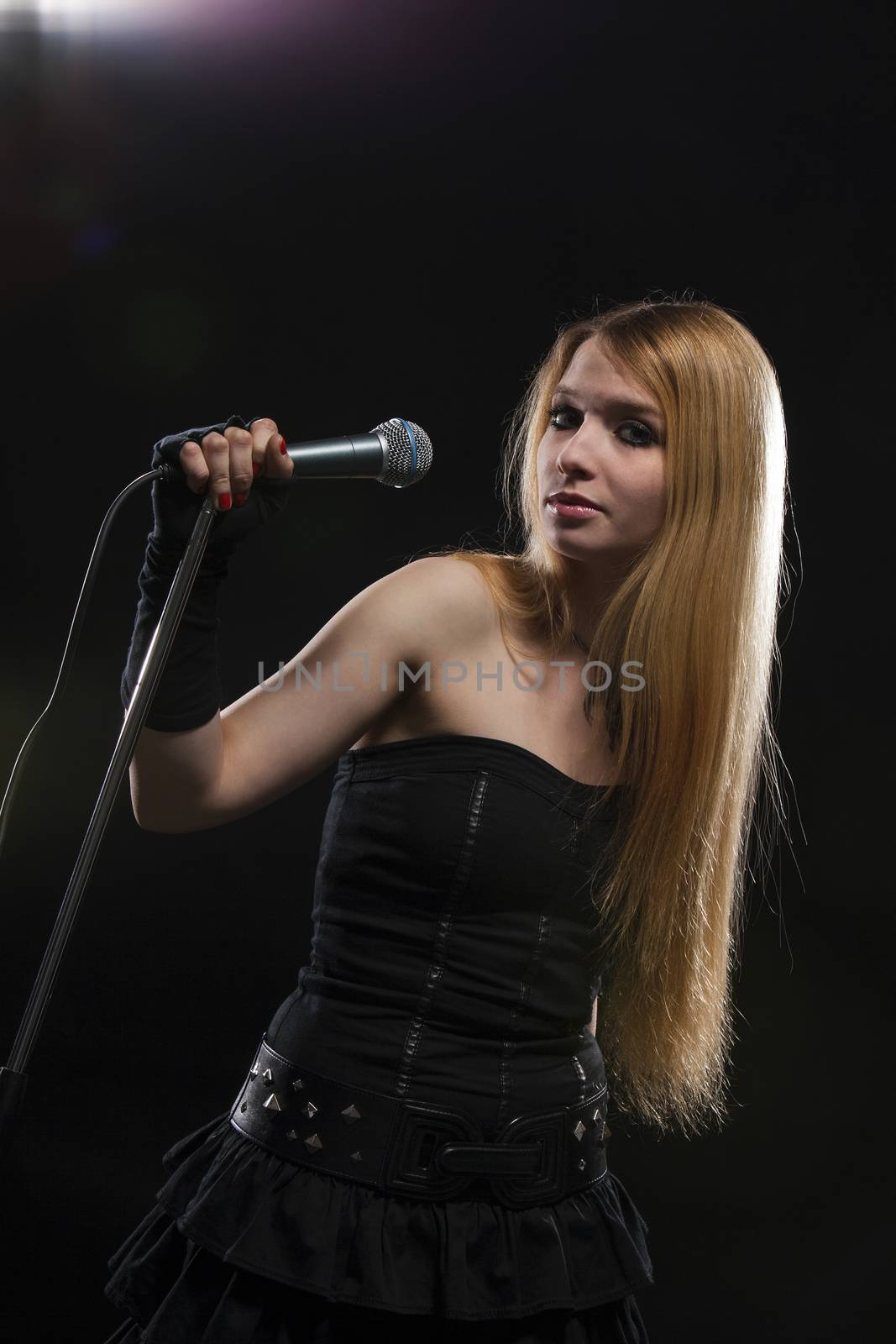 Portrait Of Female Singer Singing In Microphone
