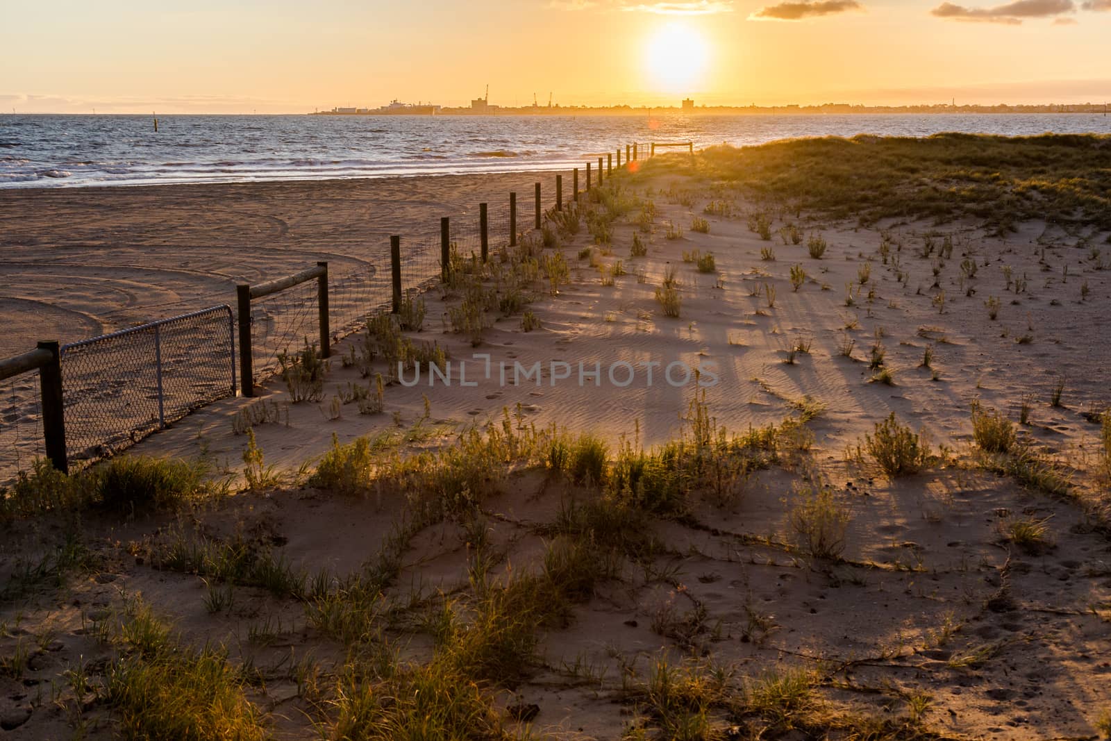 Sunset casting shadows on beach` by davidhewison