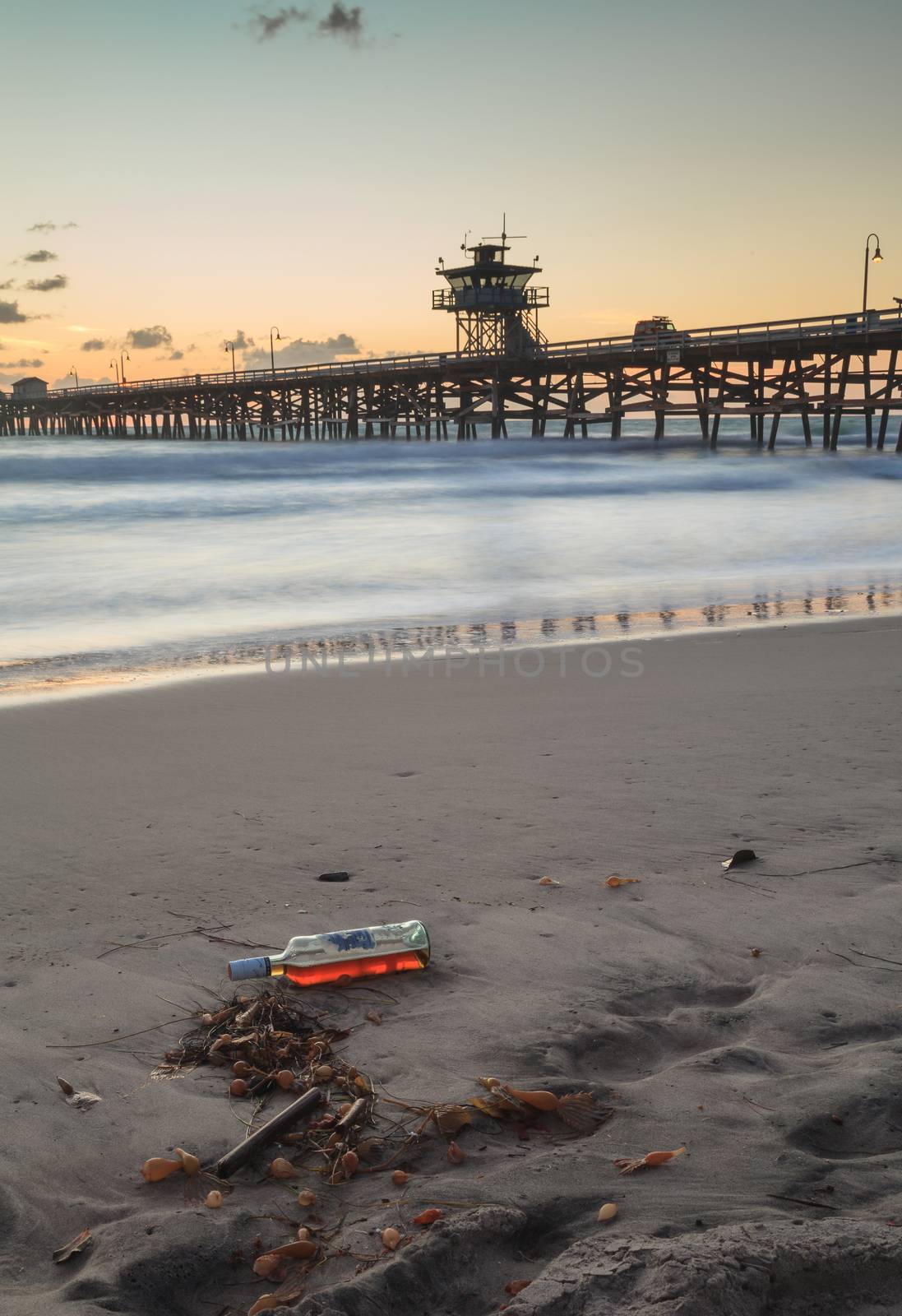 Bottle of alcohol on the beach by steffstarr