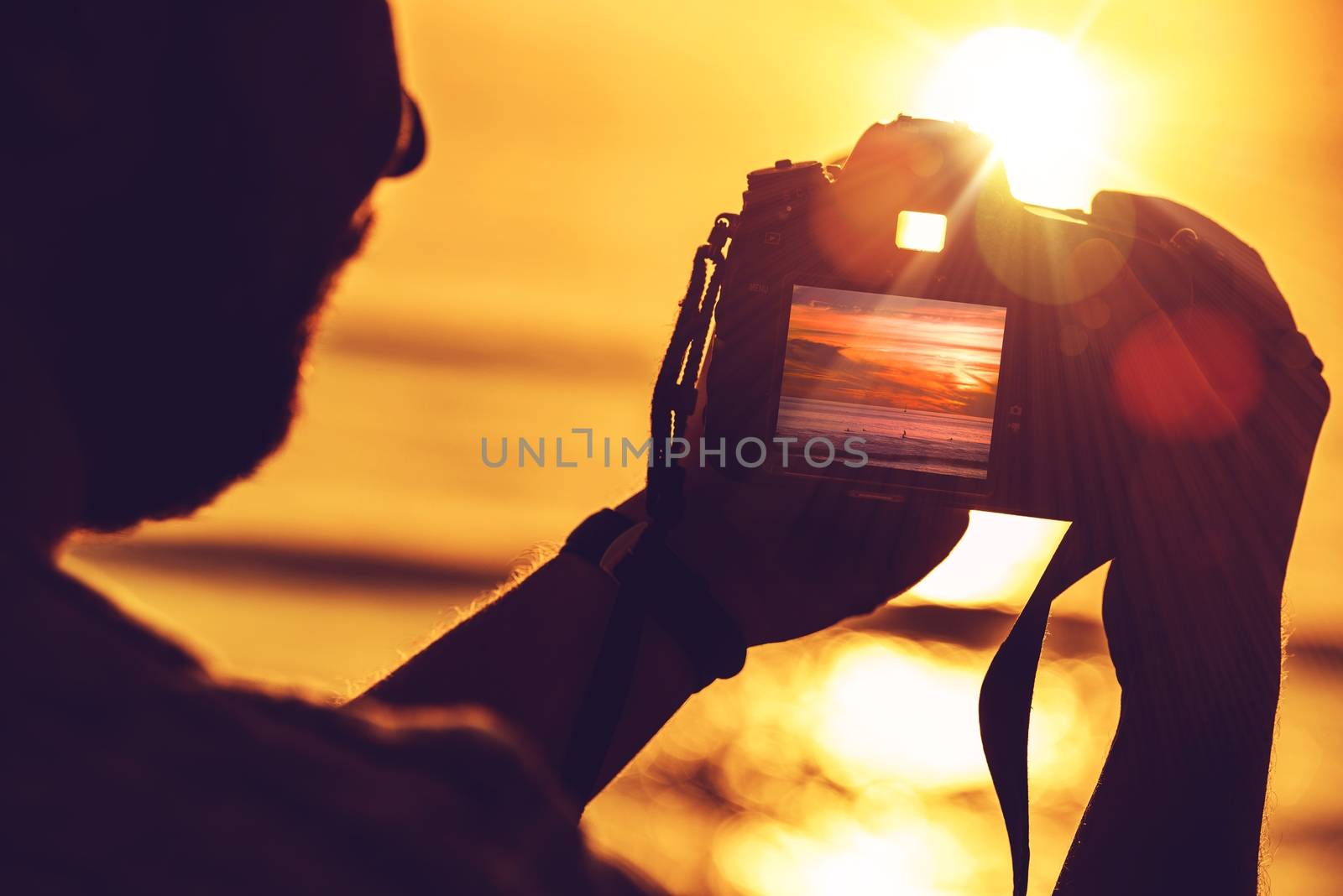 Travel Digital Photography Concept Photo with Men Playing His Professional Digital SLR Camera During Sunset.