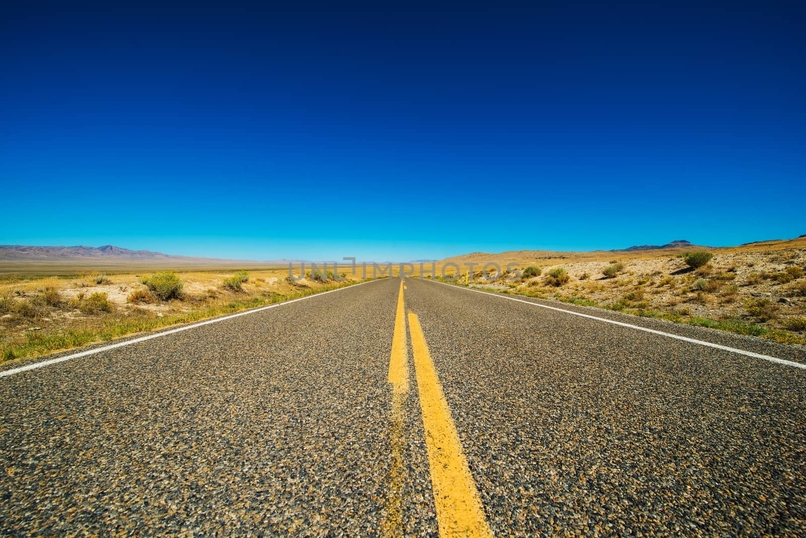 Nevada Backcountry Straight Rural Road. Nevada Highway and Clear Blue Sky.