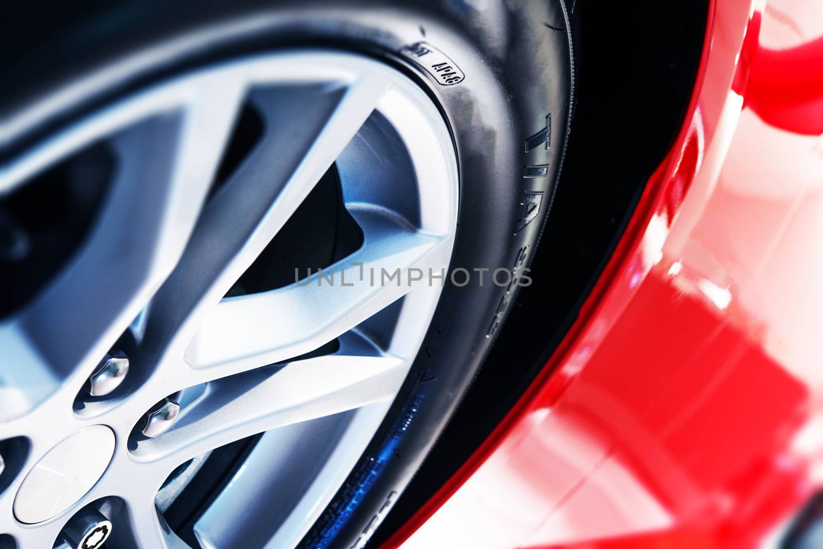 Modern Red Car Body Alloy Wheel Closeup. Modern Transportation Concept.