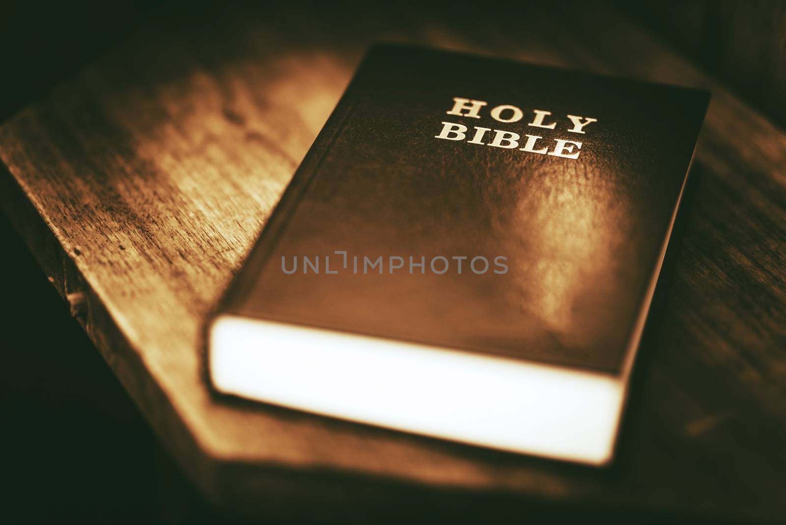 Holy Bible Closeup. Holy Bible on the Small Aged Wooden Table.