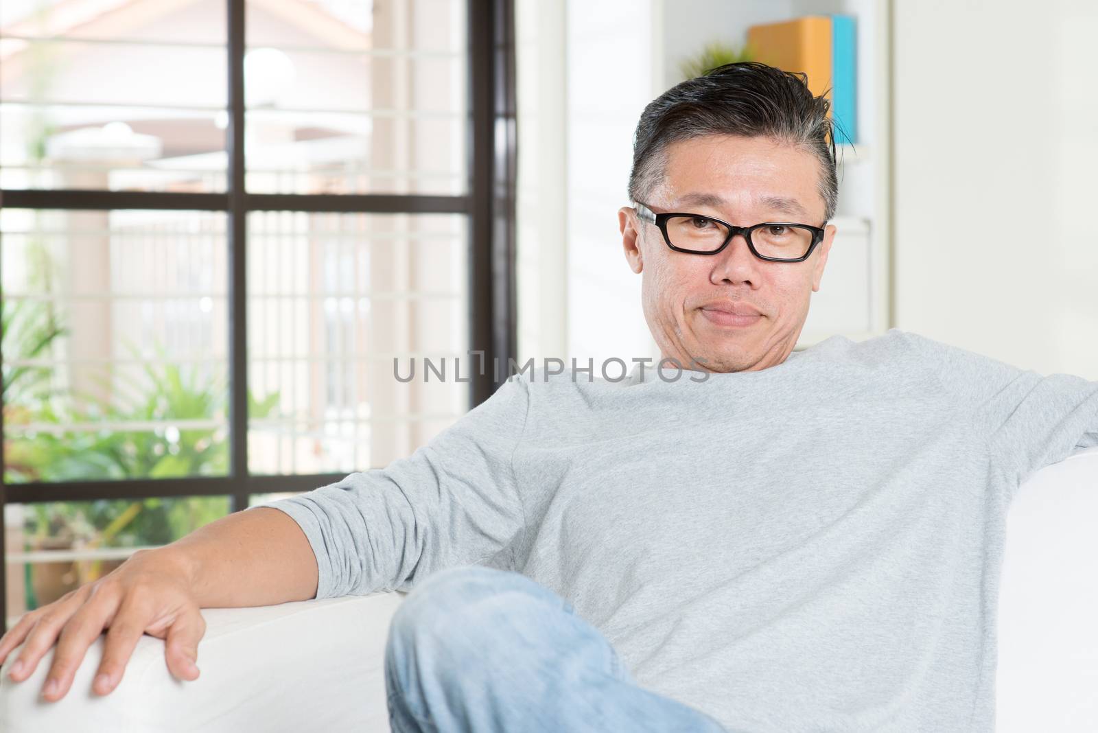 Mature 50s Asian man sitting at home. by szefei