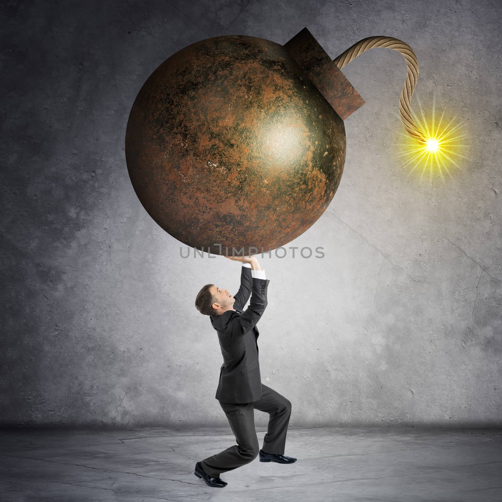 Businessman holding heavy bomb on grey wall background