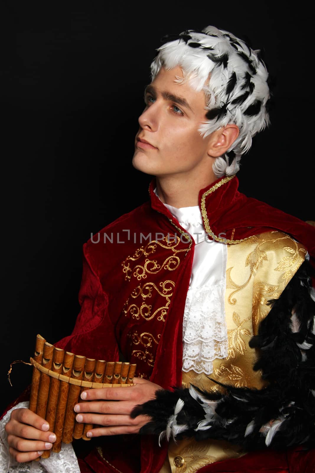 Baroque musician with reed pipe and feather in the hair