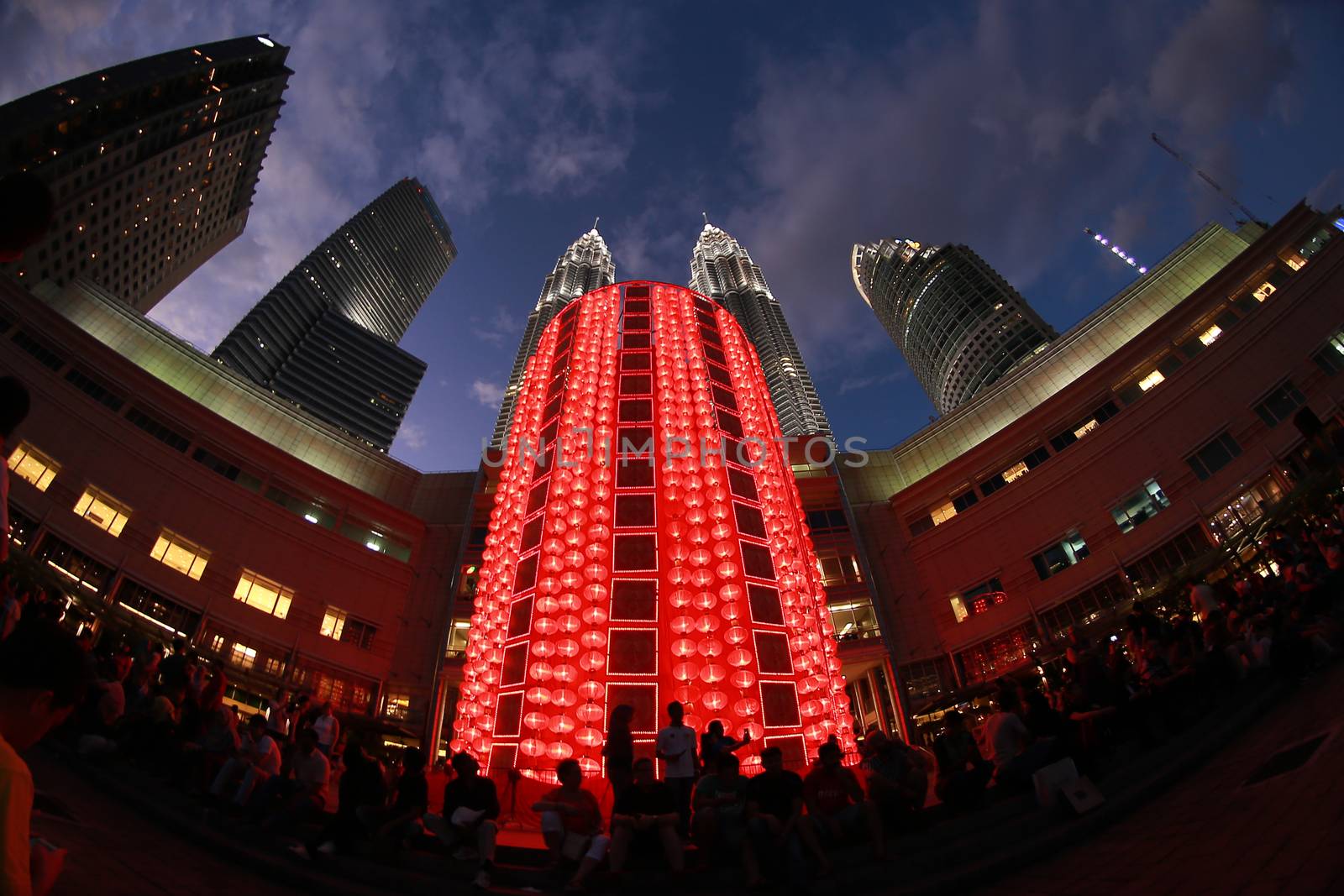MALAYSIA, Kuala Lumpur: People walk past red lantern decorations ahead of Lunar New Year celebrations at a shopping mall in front of Petronas Twin Towers in Kuala Lumpur on January 25, 2016.