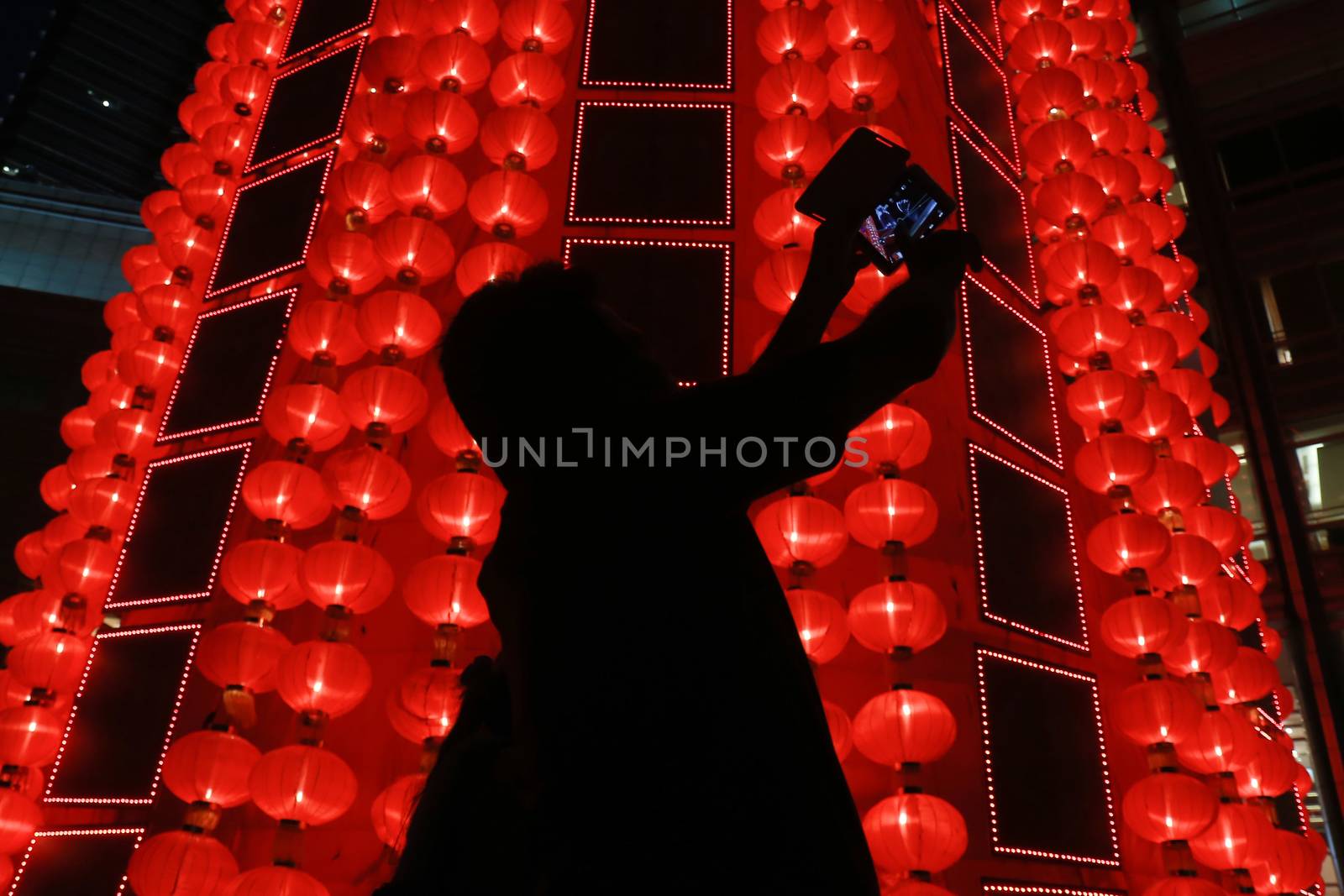 MALAYSIA, Kuala Lumpur: People walk past red lantern decorations ahead of Lunar New Year celebrations at a shopping mall in front of Petronas Twin Towers in Kuala Lumpur on January 25, 2016.