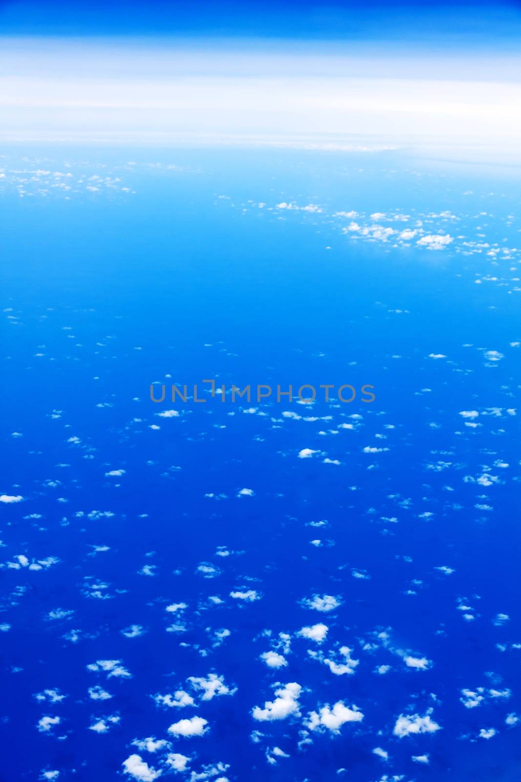 over the clouds, view during a flight over the blue ocean