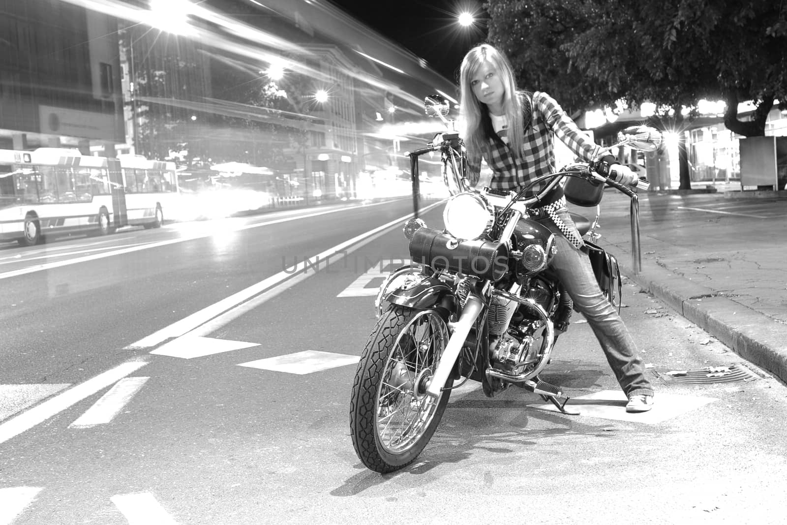 Beautiful girl on a motorcycle in a city (long exposure)