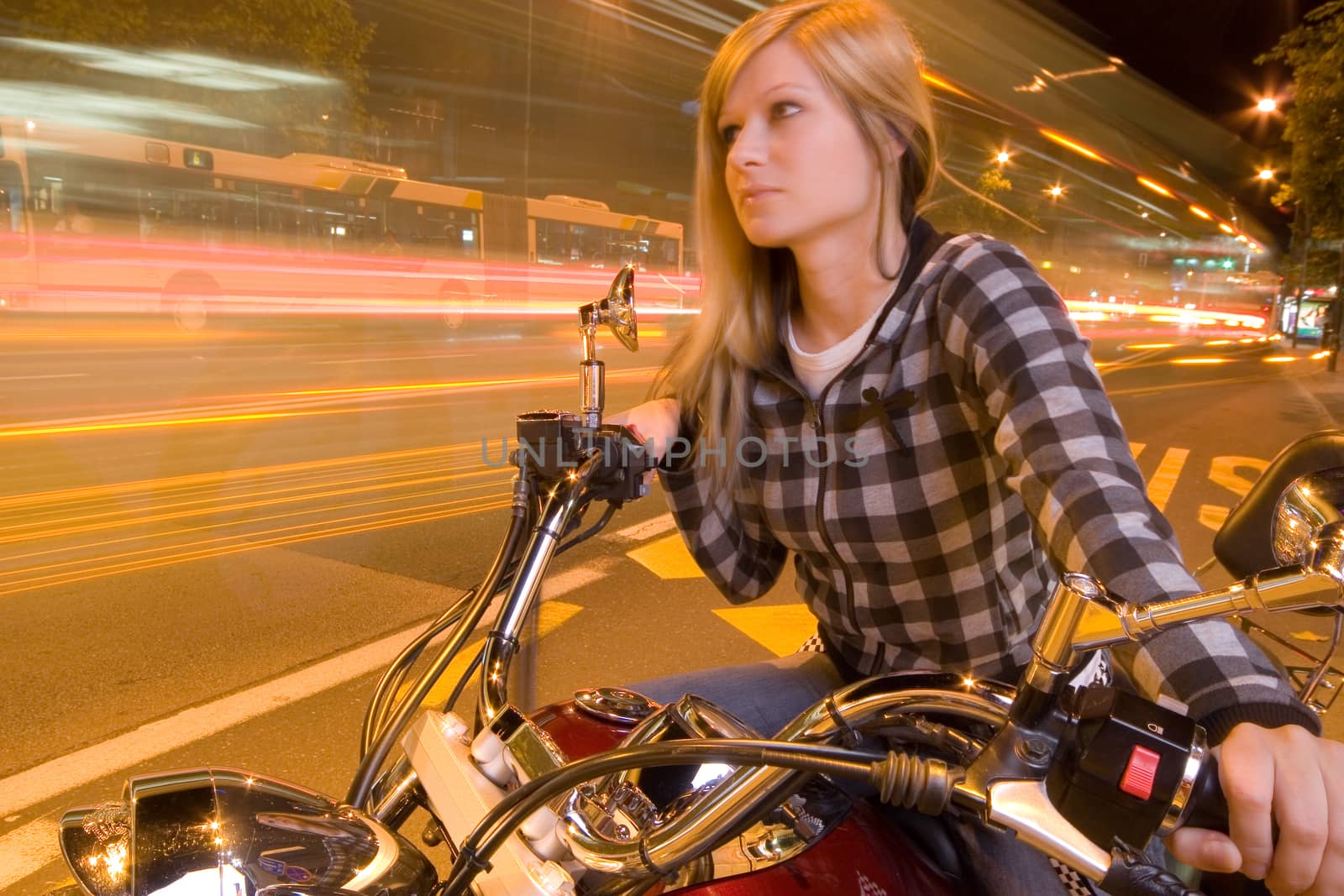 Beautiful girl on a motorcycle in a city (long exposure)