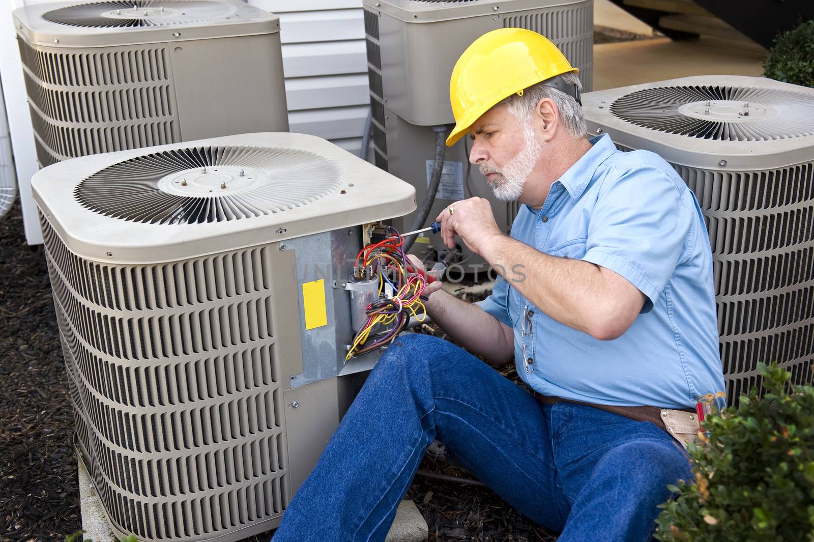 Horizontal shot of air conditioning repairman at work.