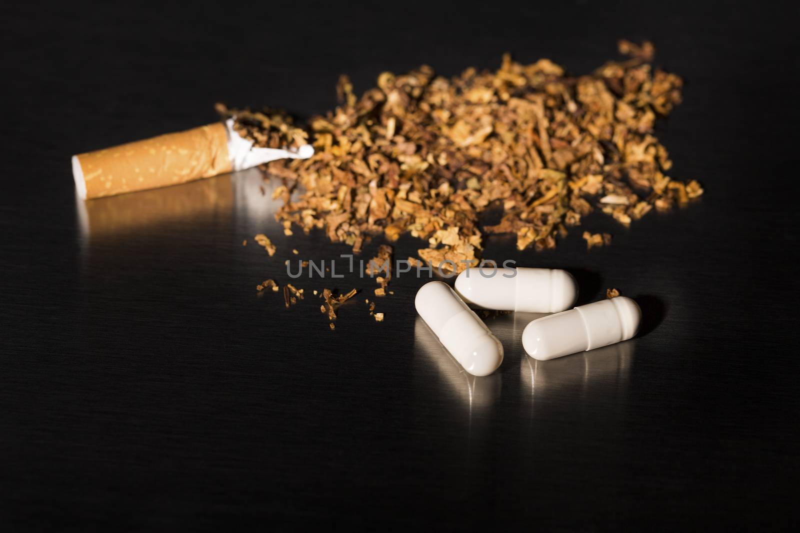 Broken cigarette on black background, reflected, stop smoking, with gum