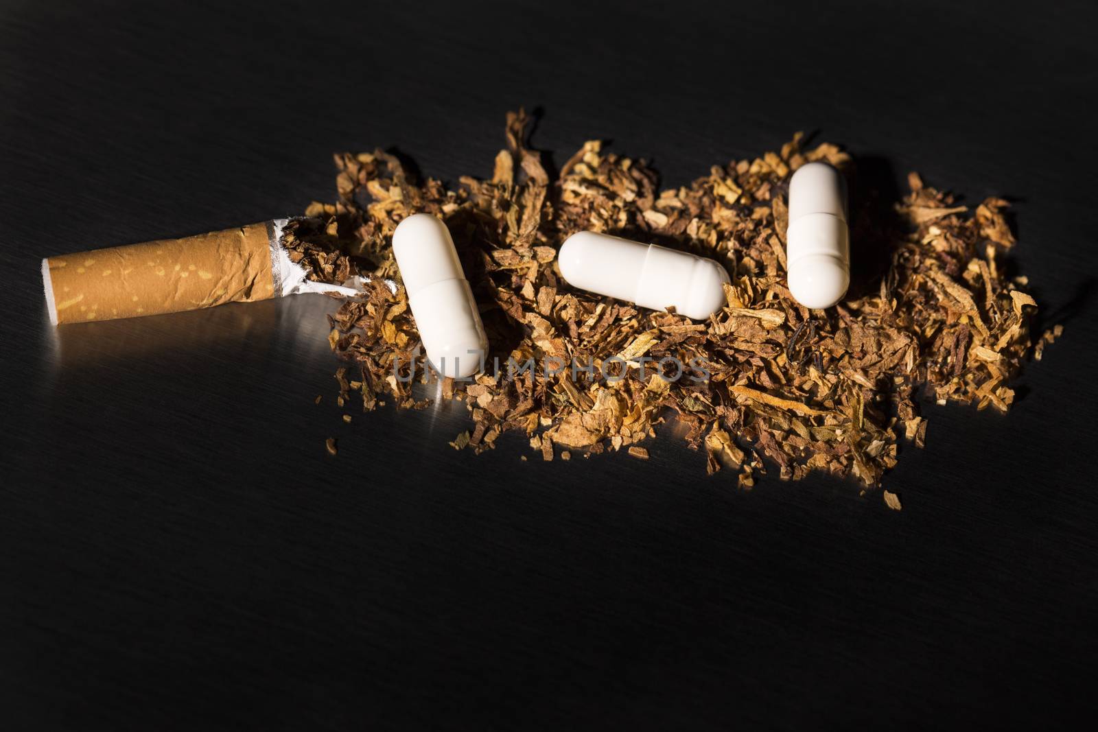 Broken cigarette on black background, reflected, stop smoking, with drug