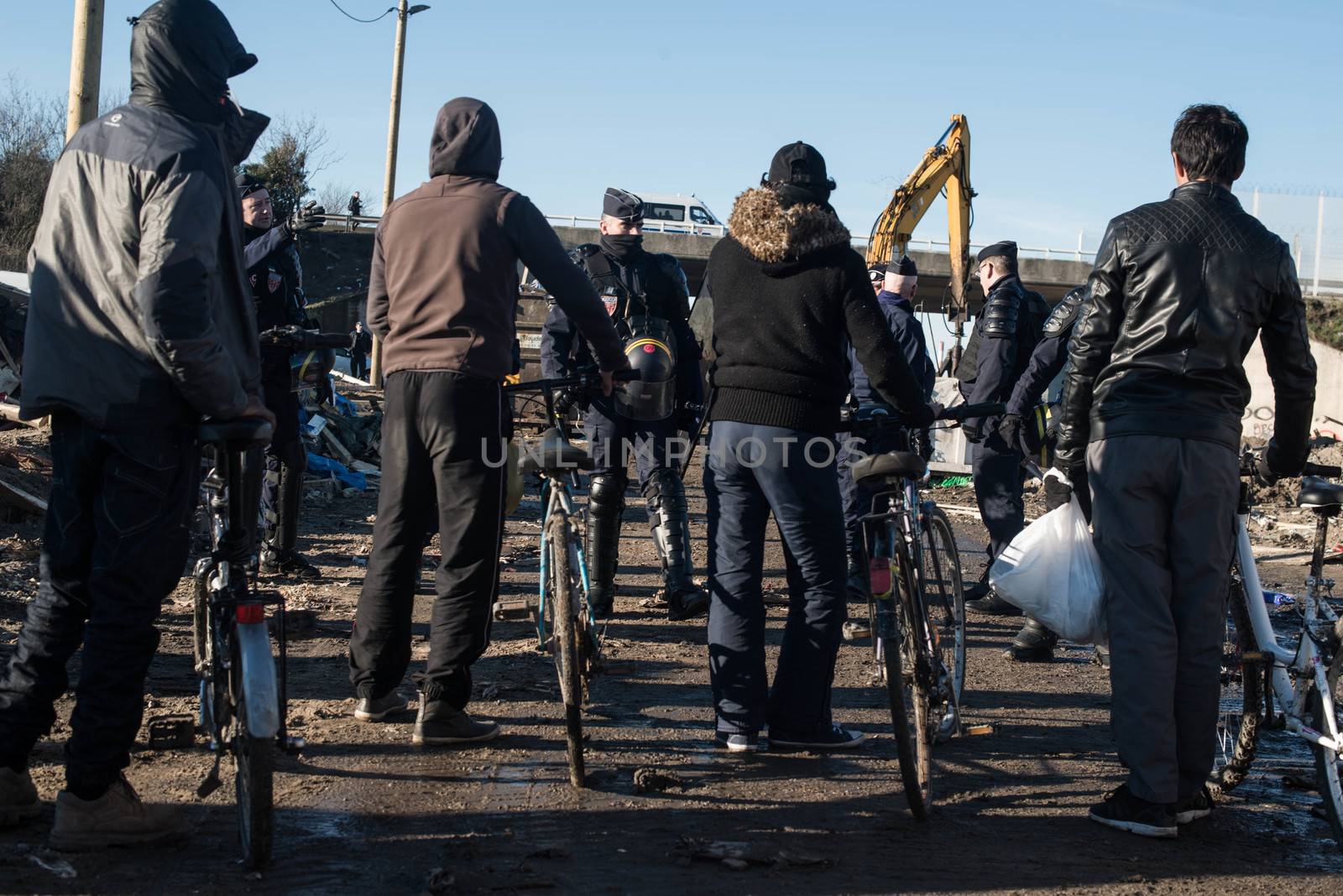 FRANCE, Calais: French riot police patrol on January 25, 2016, in a zone where makeshift shelters were cleared from in the migrant shantytown on the outskirts of Calais known as the Jungle, where thousands are trying to make their way across the English Channel.A prefectoral decree posted on January 19, 2016, gave people 24 hours to leave the premises of a 100-metre-wide strip of land in the jungle, where several small food businesses and restaurants had been set up, before its evacuation and destruction.