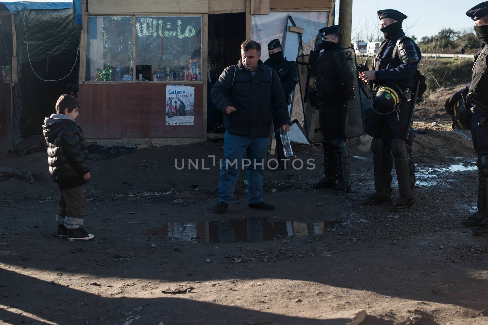 FRANCE, Calais: French riot police patrol on January 25, 2016, in a zone where makeshift shelters were cleared from in the migrant shantytown on the outskirts of Calais known as the Jungle, where thousands are trying to make their way across the English Channel.A prefectoral decree posted on January 19, 2016, gave people 24 hours to leave the premises of a 100-metre-wide strip of land in the jungle, where several small food businesses and restaurants had been set up, before its evacuation and destruction.