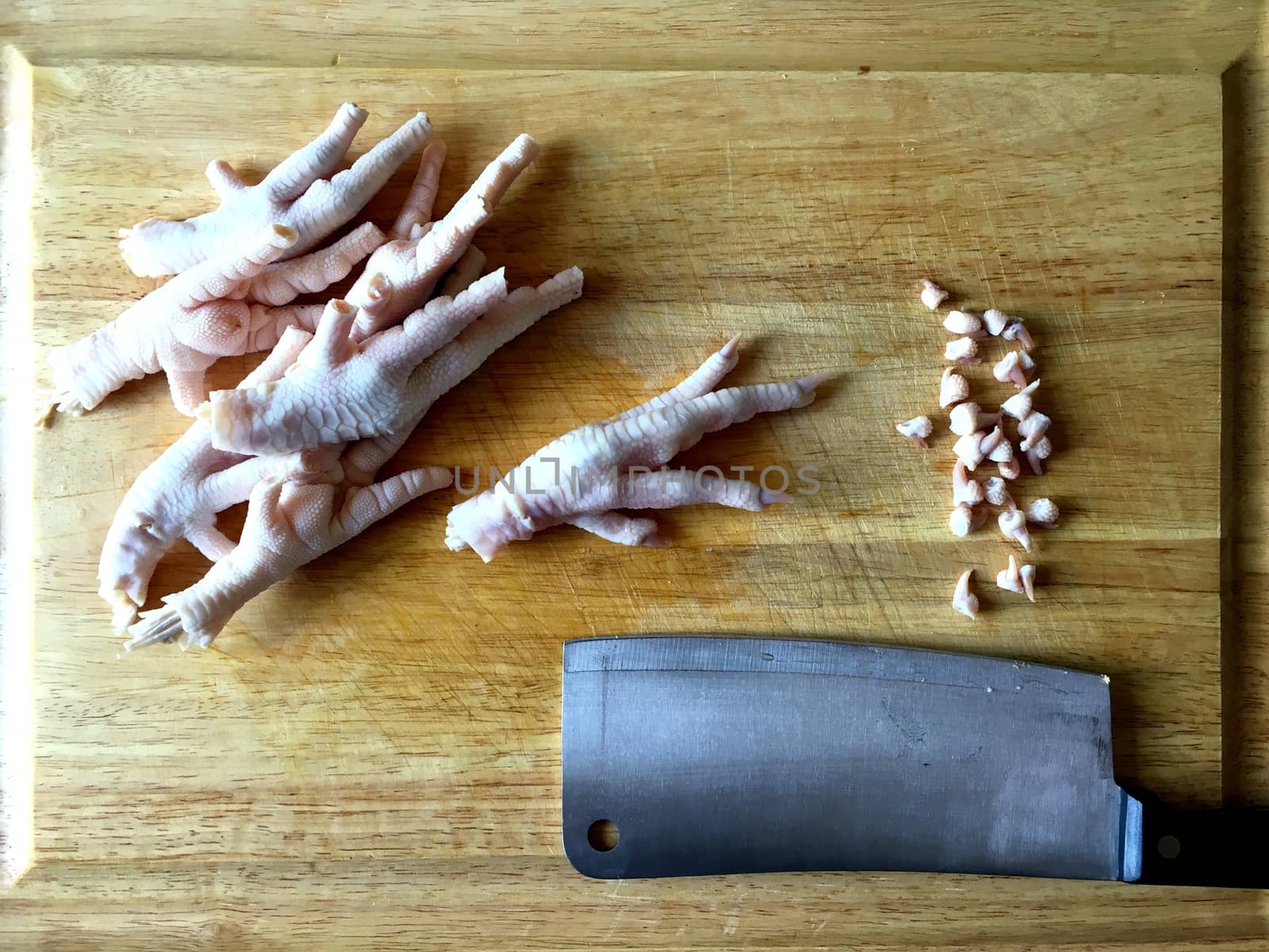 Chicken feet on cutting board with toenails cut off.