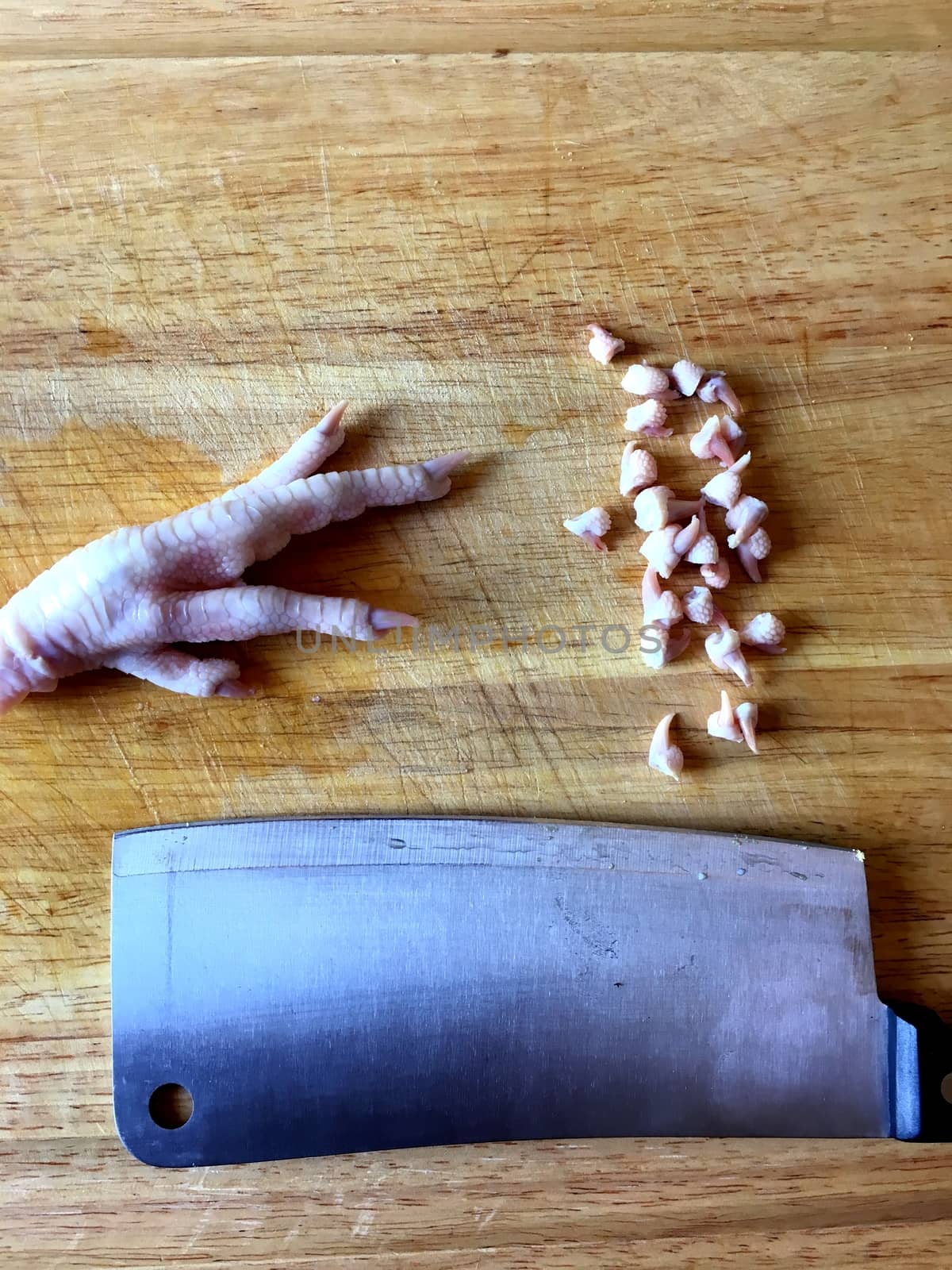 Chicken feet on cutting board with toenails cut off.