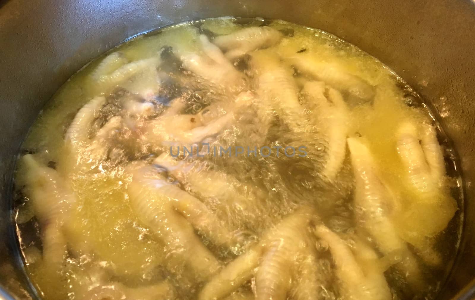 Chicken feet boiling in a pot of hot water.