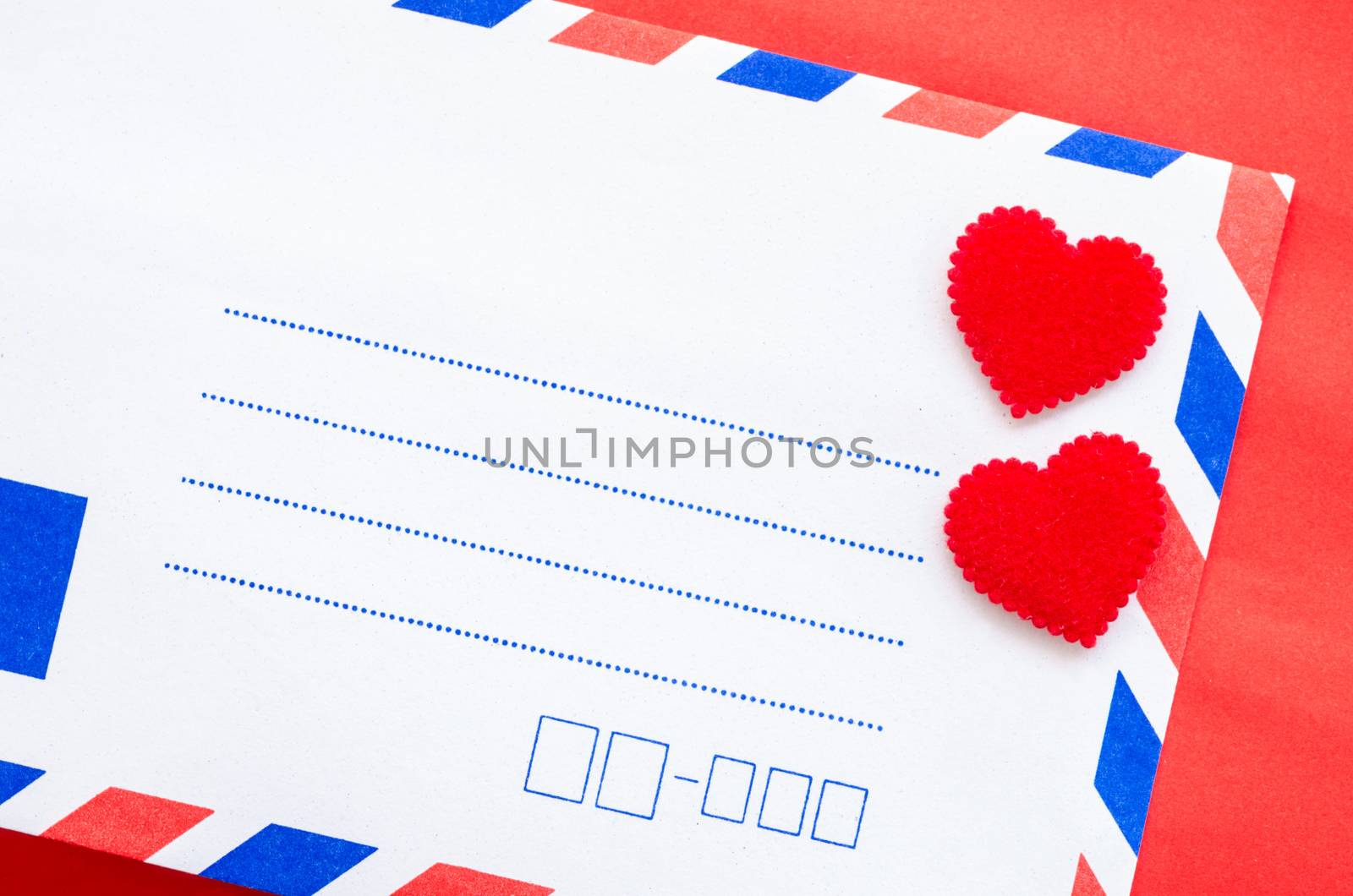 Vintage mail envelopes and red heart on red background.