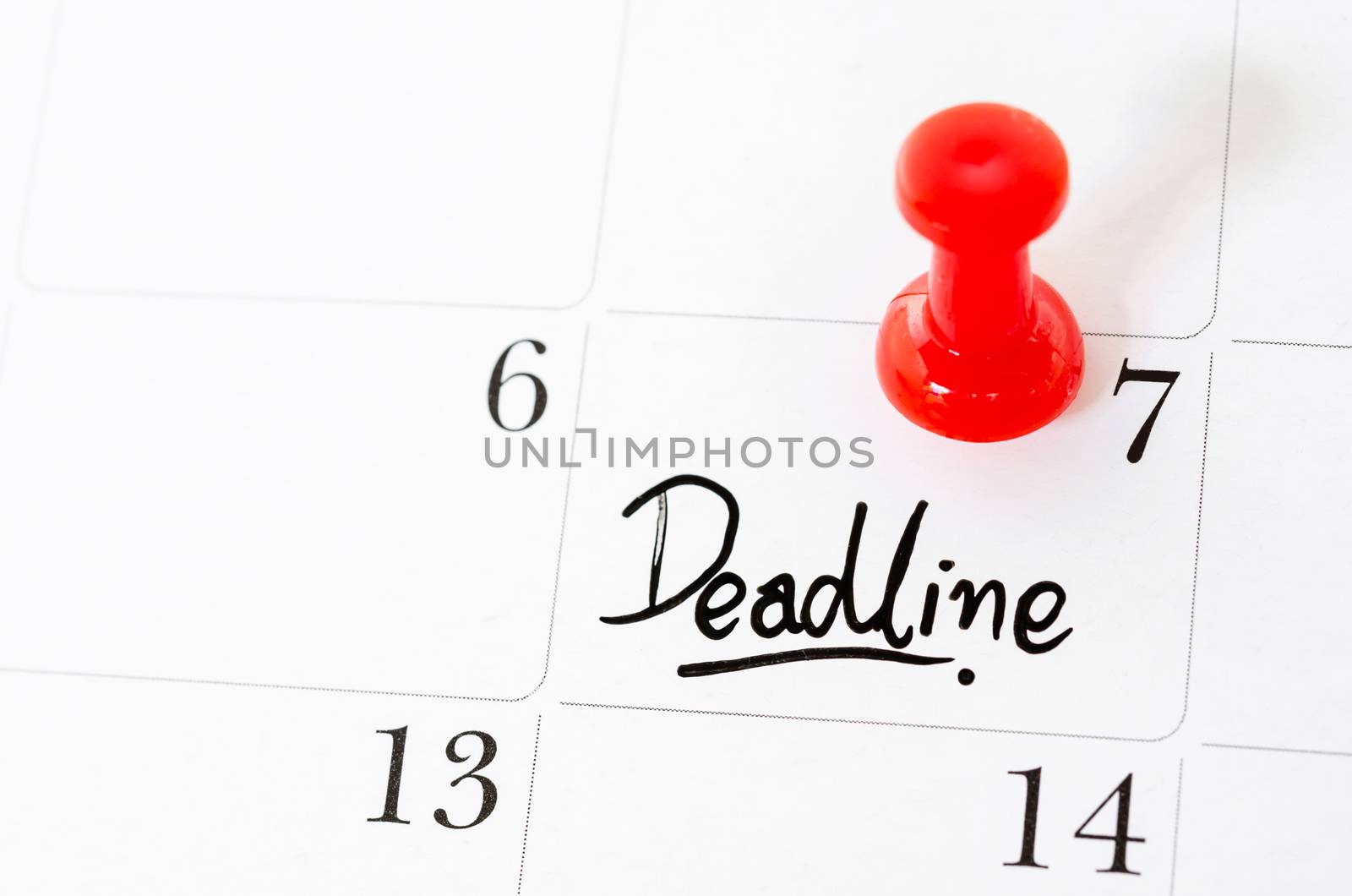 Deadline word written on the calendar with red pushpins.