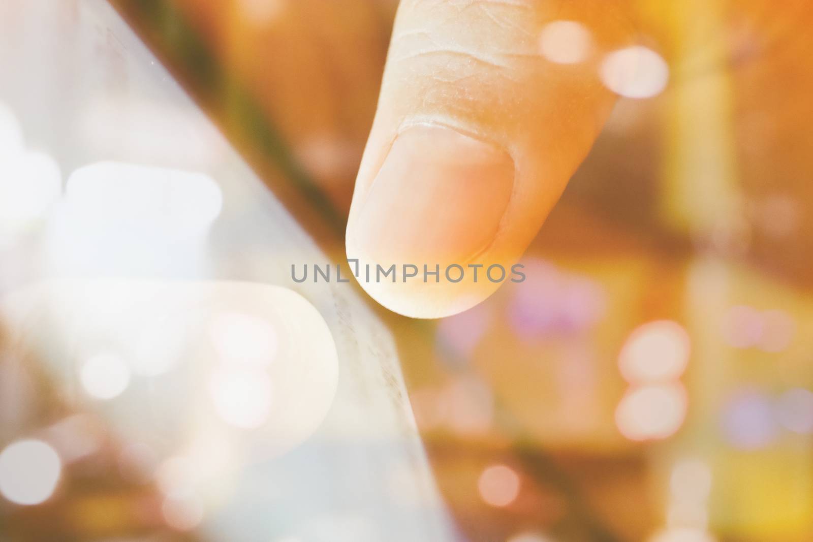 close up of Male fingers touching tablet screen double exposure and blurred view of car on street at night
