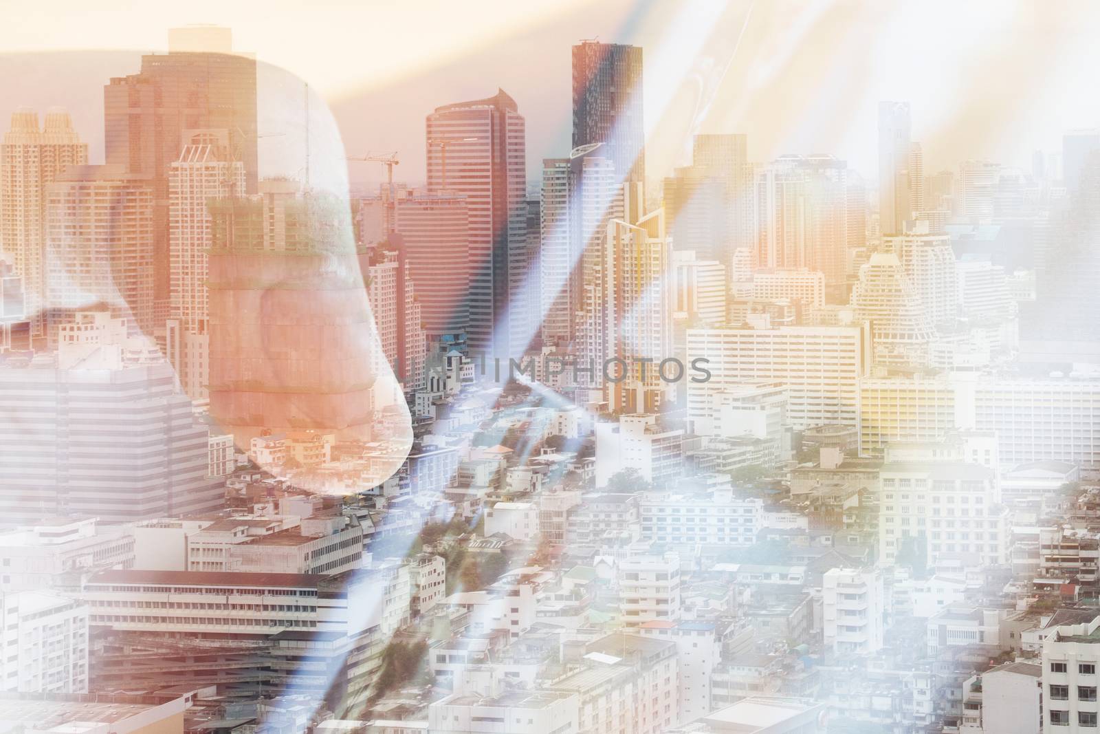 Hand touching a digital tablet double exposure and and cityscape background. communication technology concept.