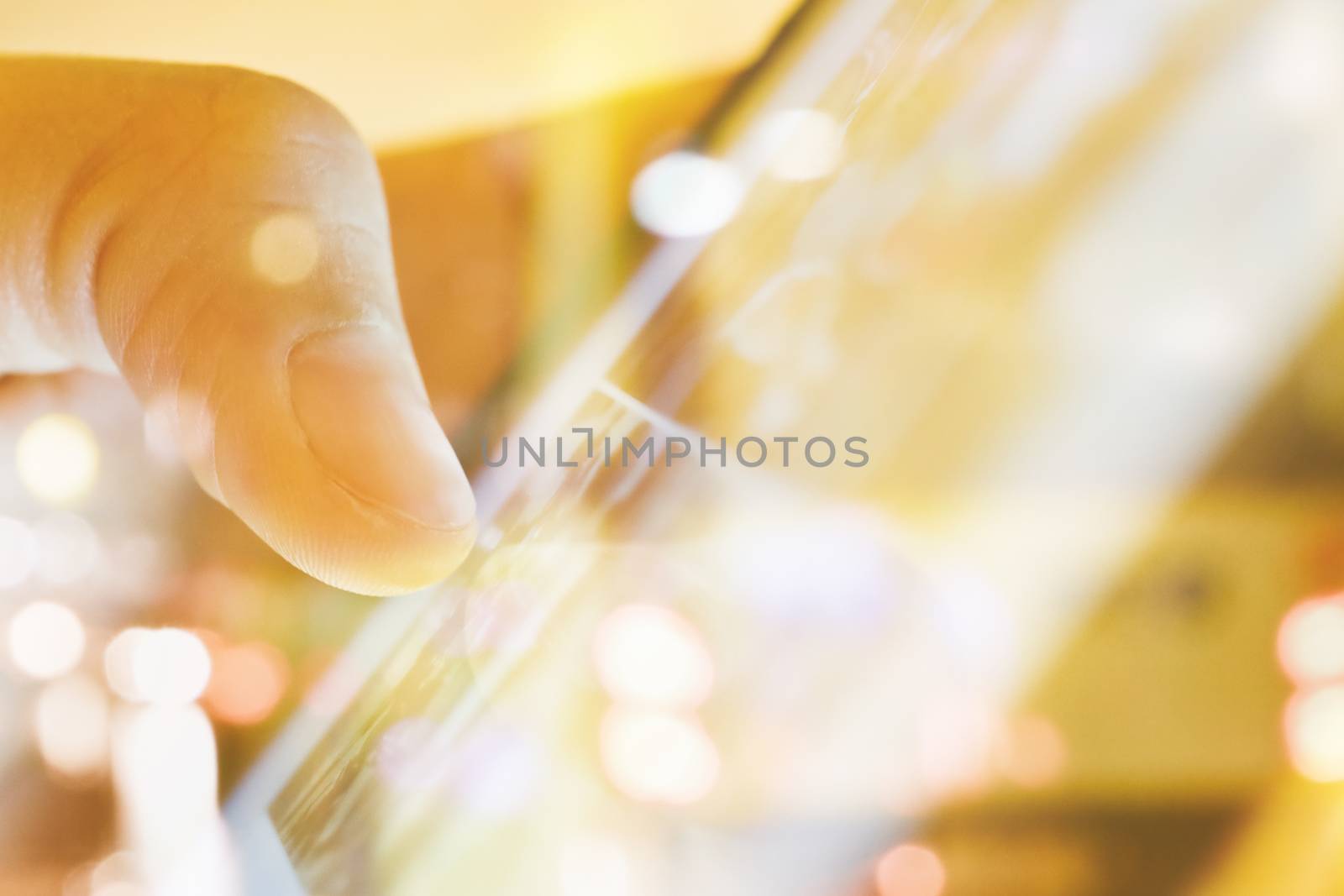 close up of Male fingers touching tablet screen double exposure and blurred view of car on street at night