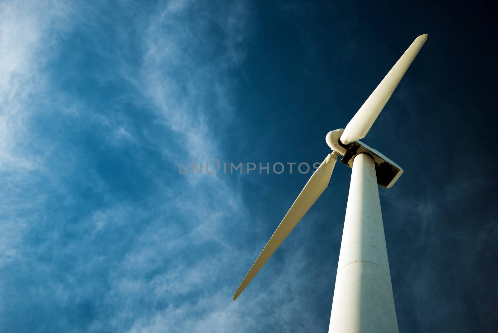 Lonely Wind Turbine and the Dark Cloudy Blue Sky. Wind Energy.