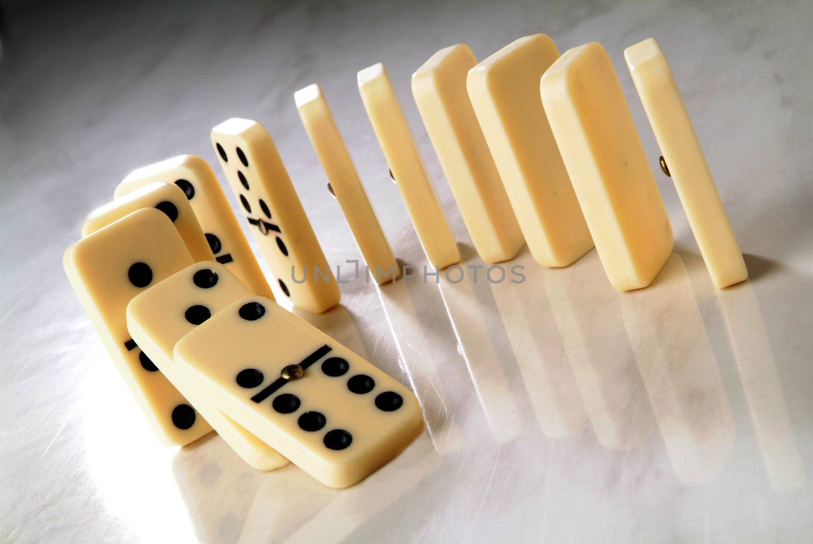 row of dominoes in a semicircle shape on a neutral background