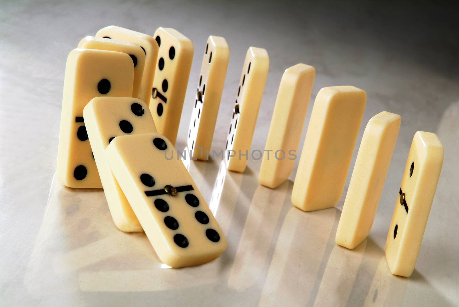 row of dominoes in a semicircle shape on a neutral background