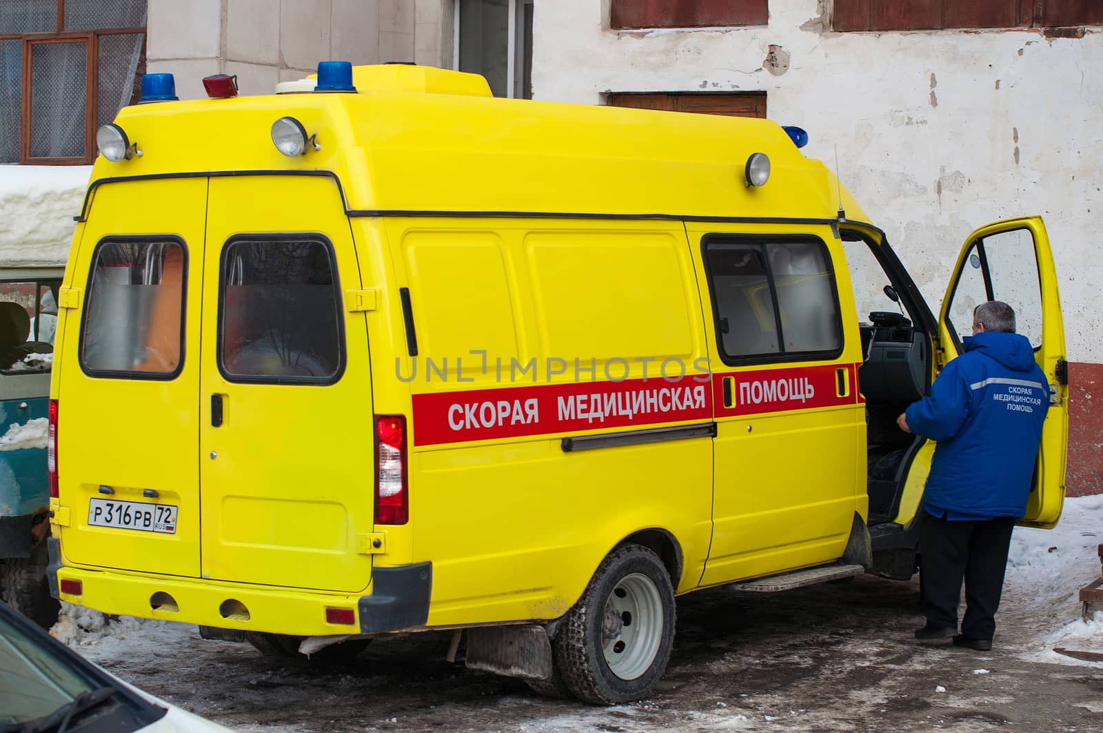 The yellow car of an emergency medical service costs at a house entrance. Tyumen, Russia