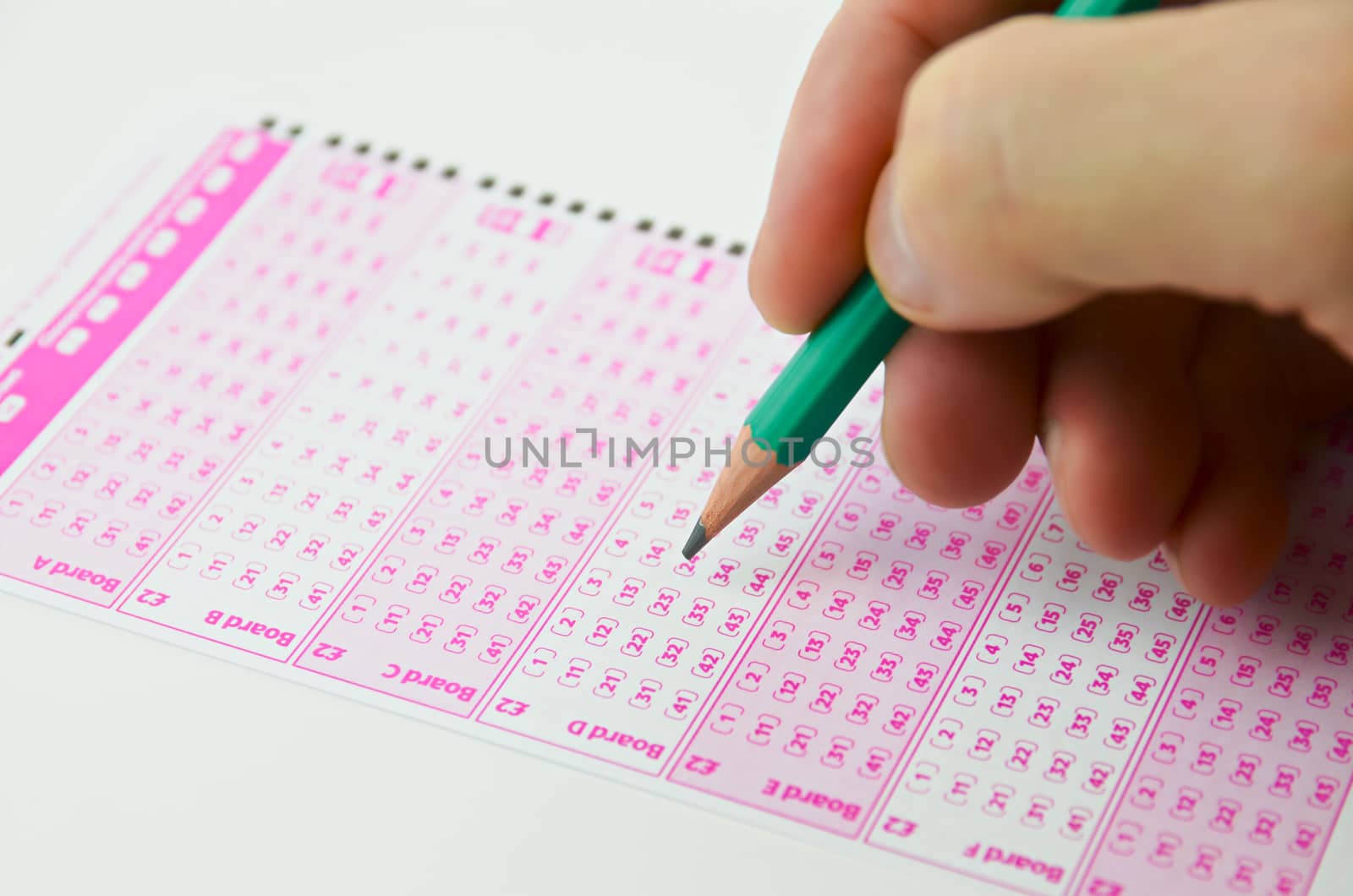 Close-up marking number on lottery ticket with pencil


