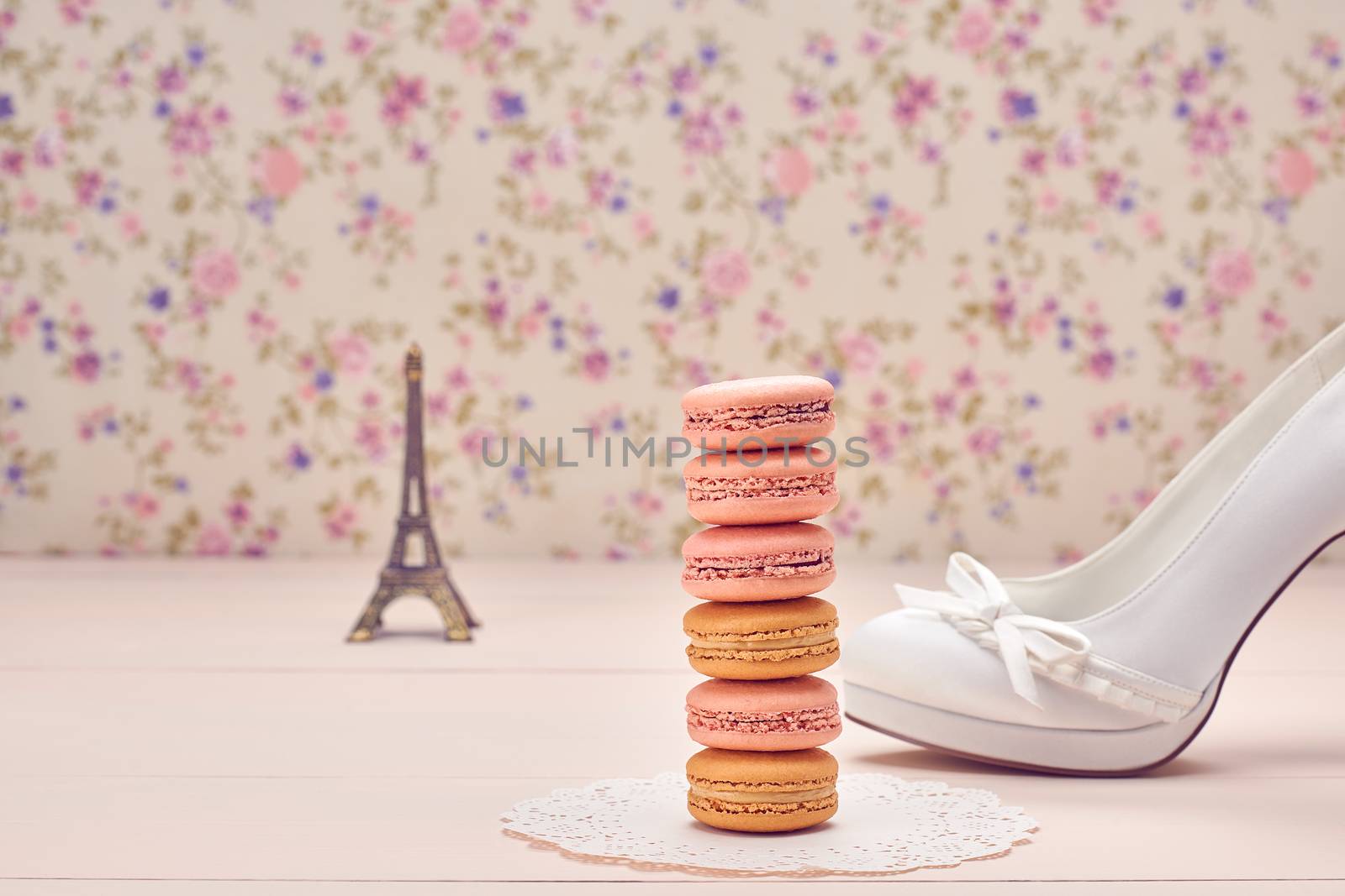 Macarons french dessert. Eiffel Tower, souvenir from Paris,  luxury shoes high heels. Creative wedding set, vanilla wood, floral background. Romantic, still life. Retro vintage 