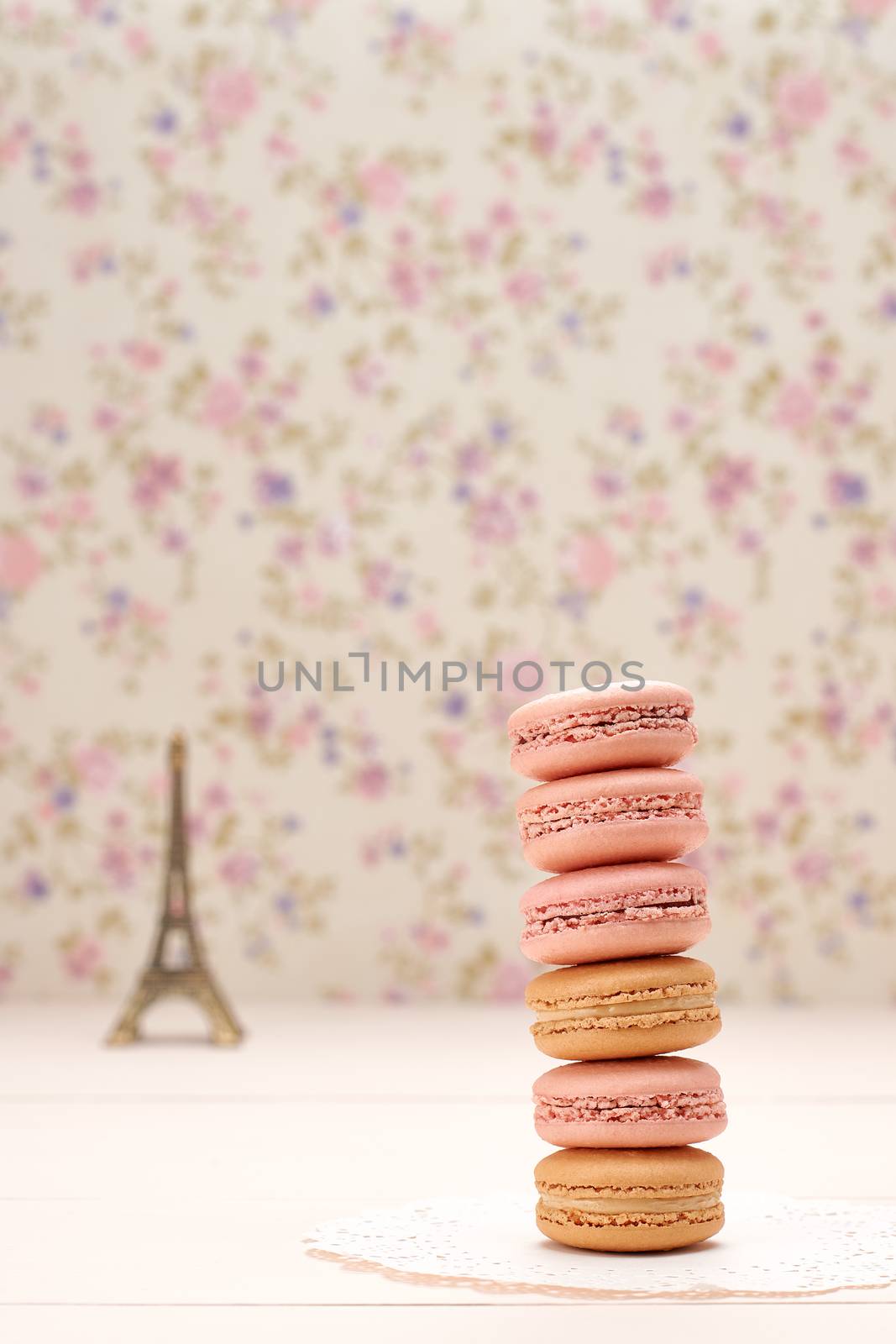 Macarons french dessert, stack. Eiffel Tower, souvenir from Paris, Fresh pastel dessert. Creative wedding set, vanilla wood, floral background. Romantic, still life. Retro vintage 