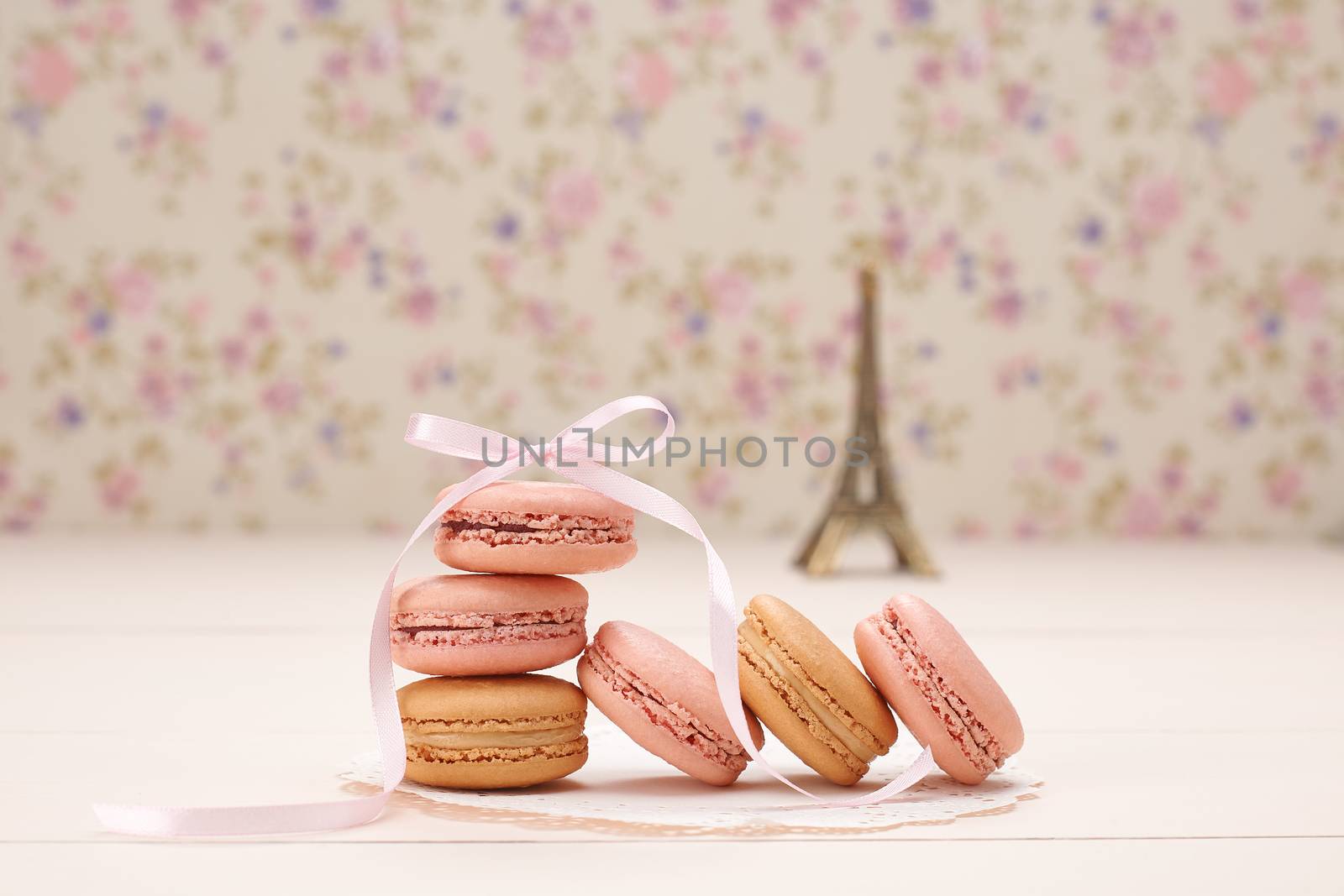 Macarons french dessert. Eiffel Tower, souvenir from Paris, Fresh pastel dessert, pink ribbon. Creative wedding set, vanilla wood, floral background. Romantic, still life. Retro vintage 