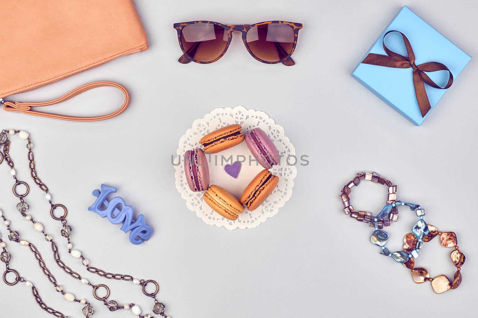 Overhead outfit Fashion clothes set, macarons french dessert, accessories. Glamor creative, love, clutch sunglasses gift box, necklace, bracelet. Unusual modern party essentials.Top view,background