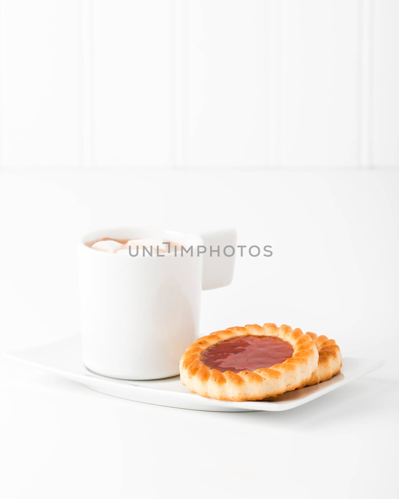 Strawberry jam filled cookies served with hot chocolate.