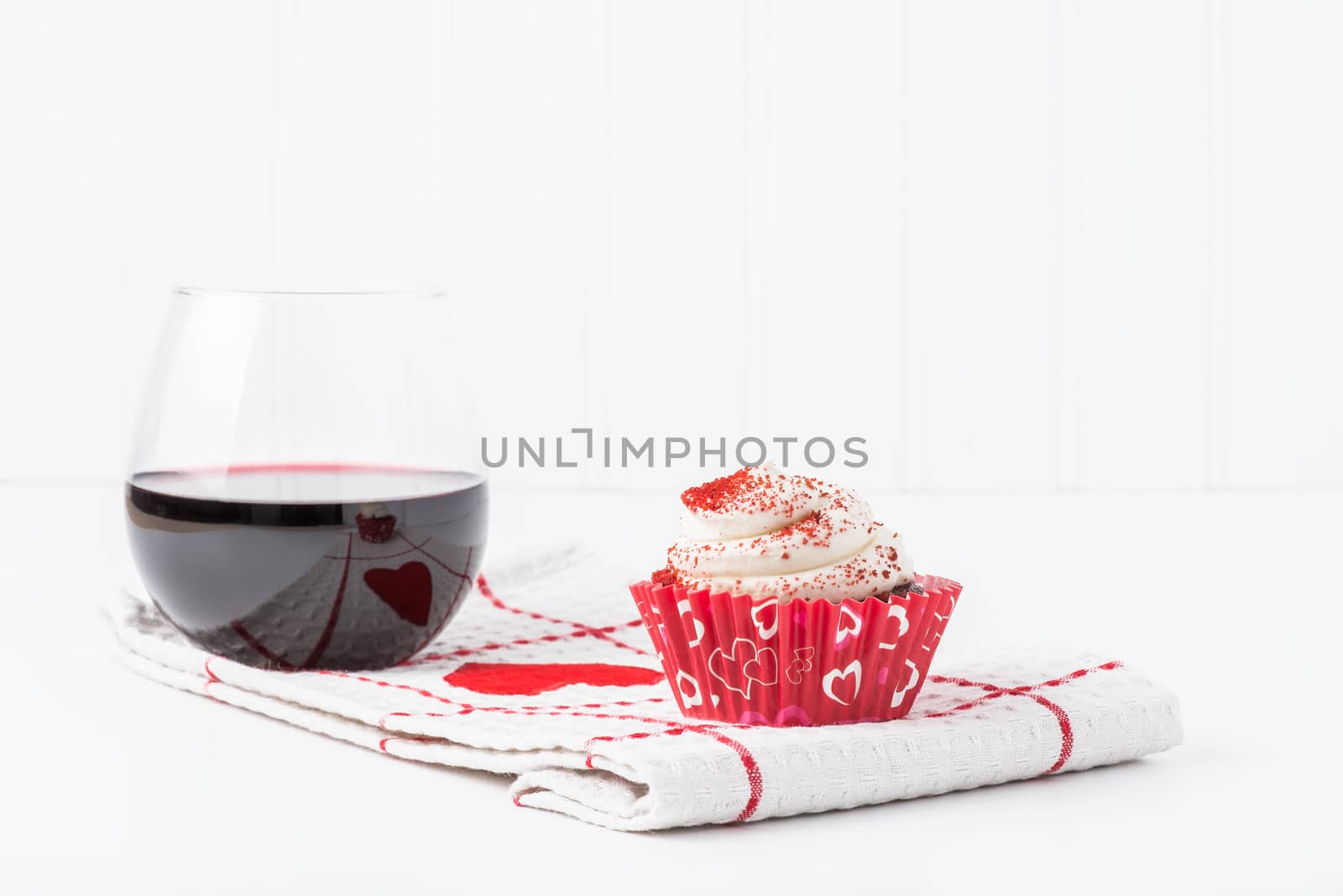 Valentines dessert of a red velvet cupcake and a glass of red wine.