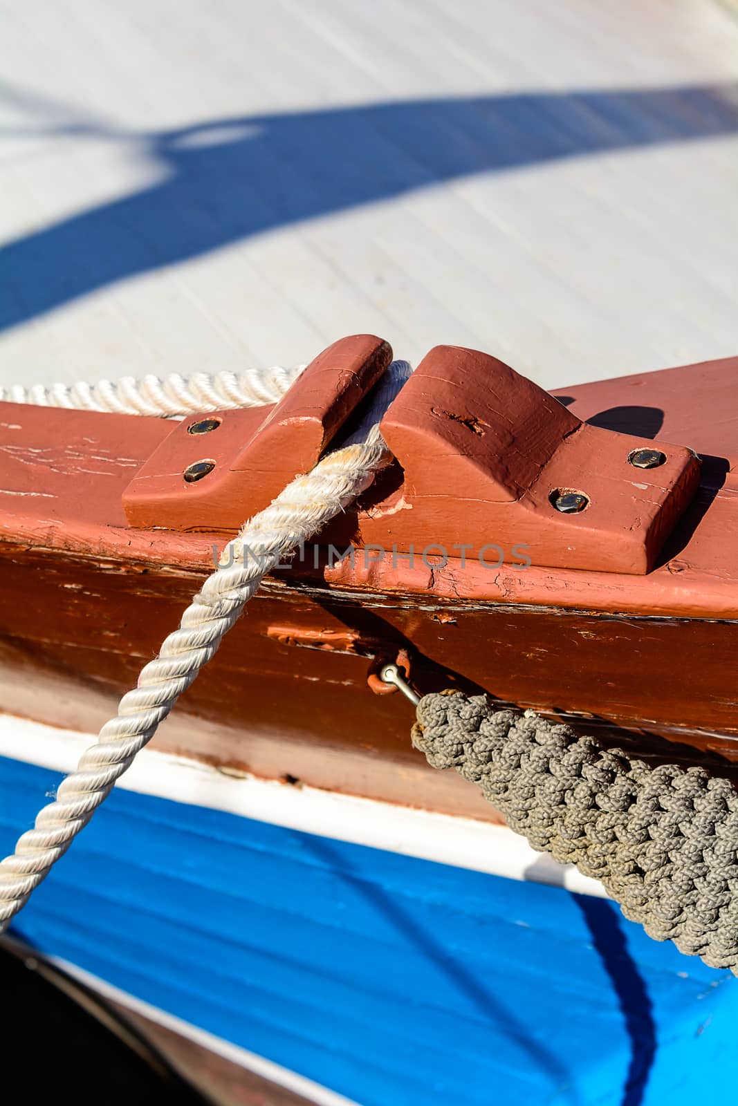 Fragmentary view details of knots and ropes on the yacht moored in the dock. Passing through the anchor.