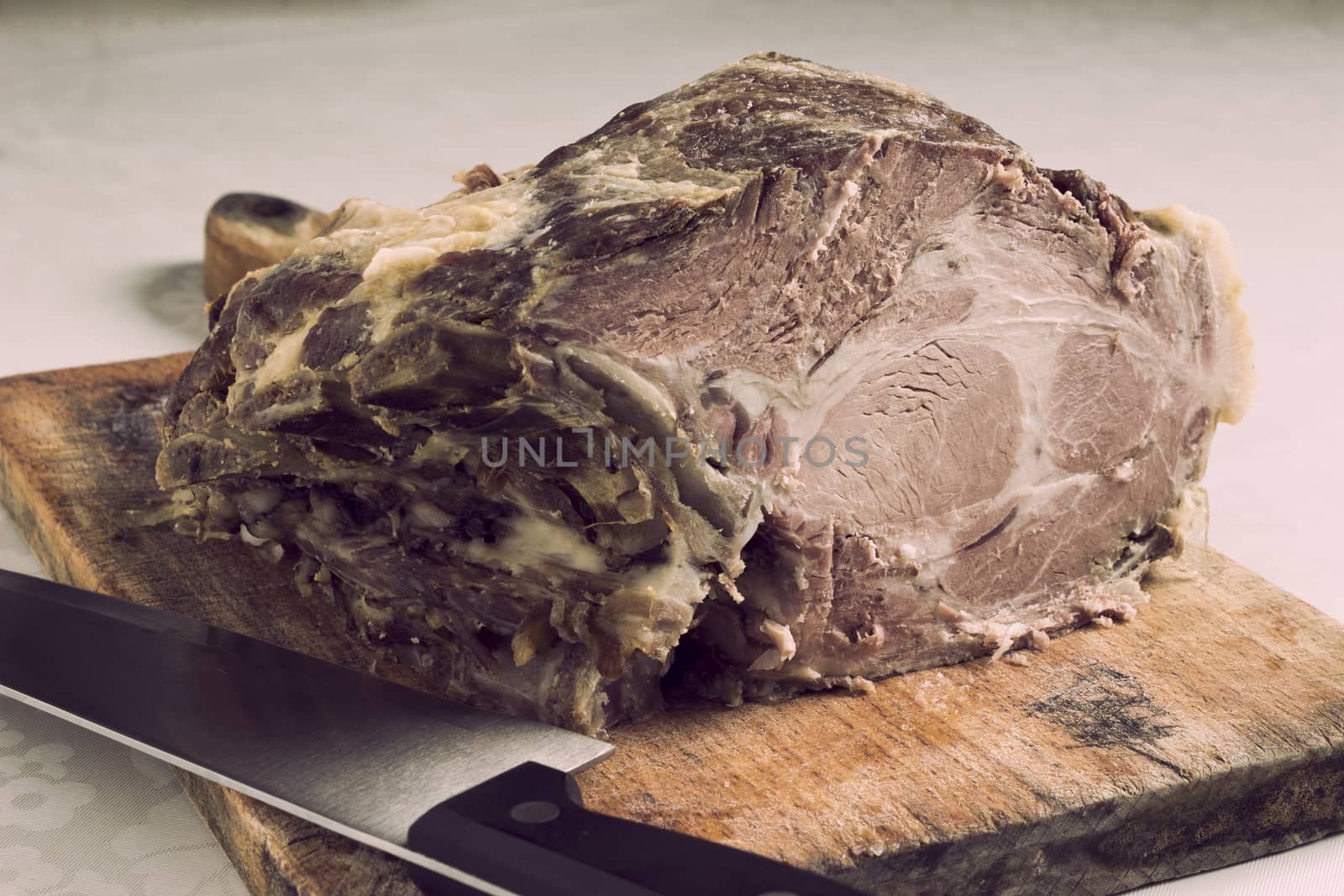 Roast pork neck on a cutting board - vintage look