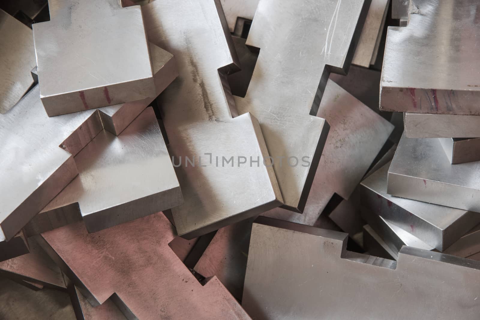 Pile of stainless steel blocks. Shallow depth of field with some of the blocks in focus.
