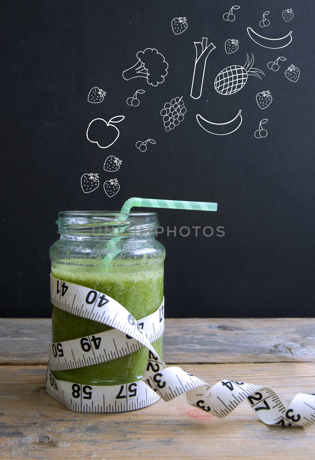 Healthy fruits and vegetables sketched on a chalkboard appearing to fall into a fruit smoothie jar with tape measure