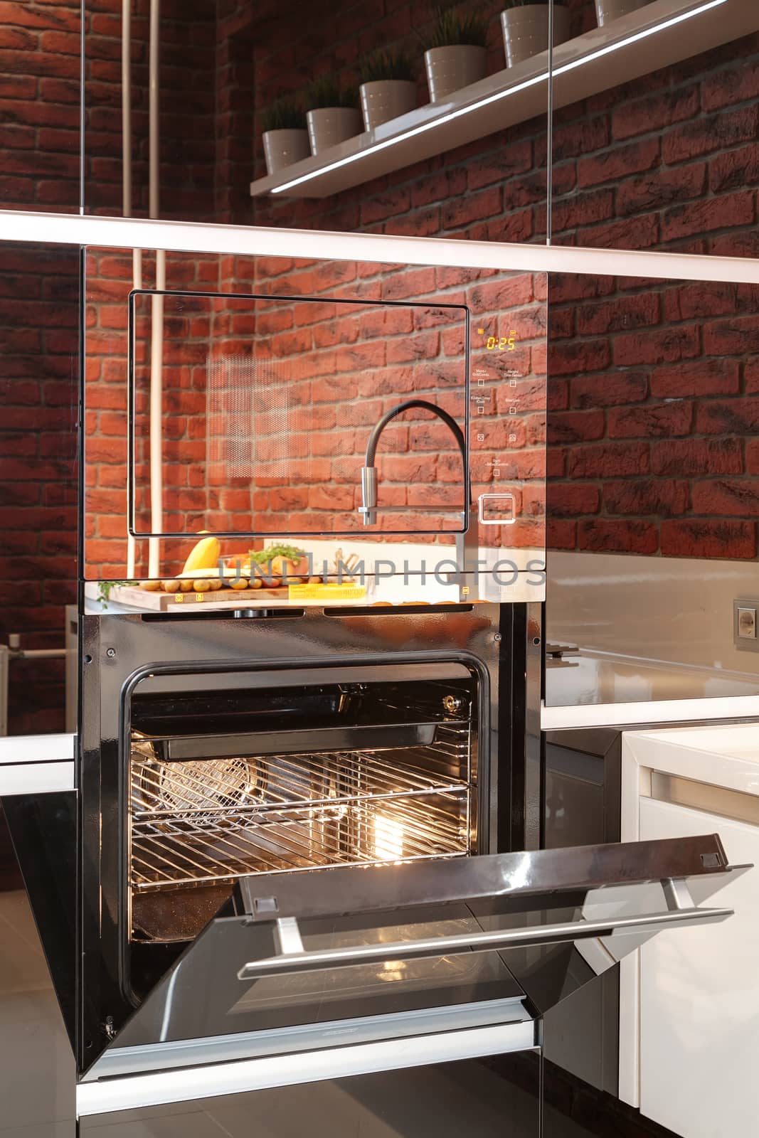 the modern mixer with a sink and vegetables on a kitchen table in reflection on an oven