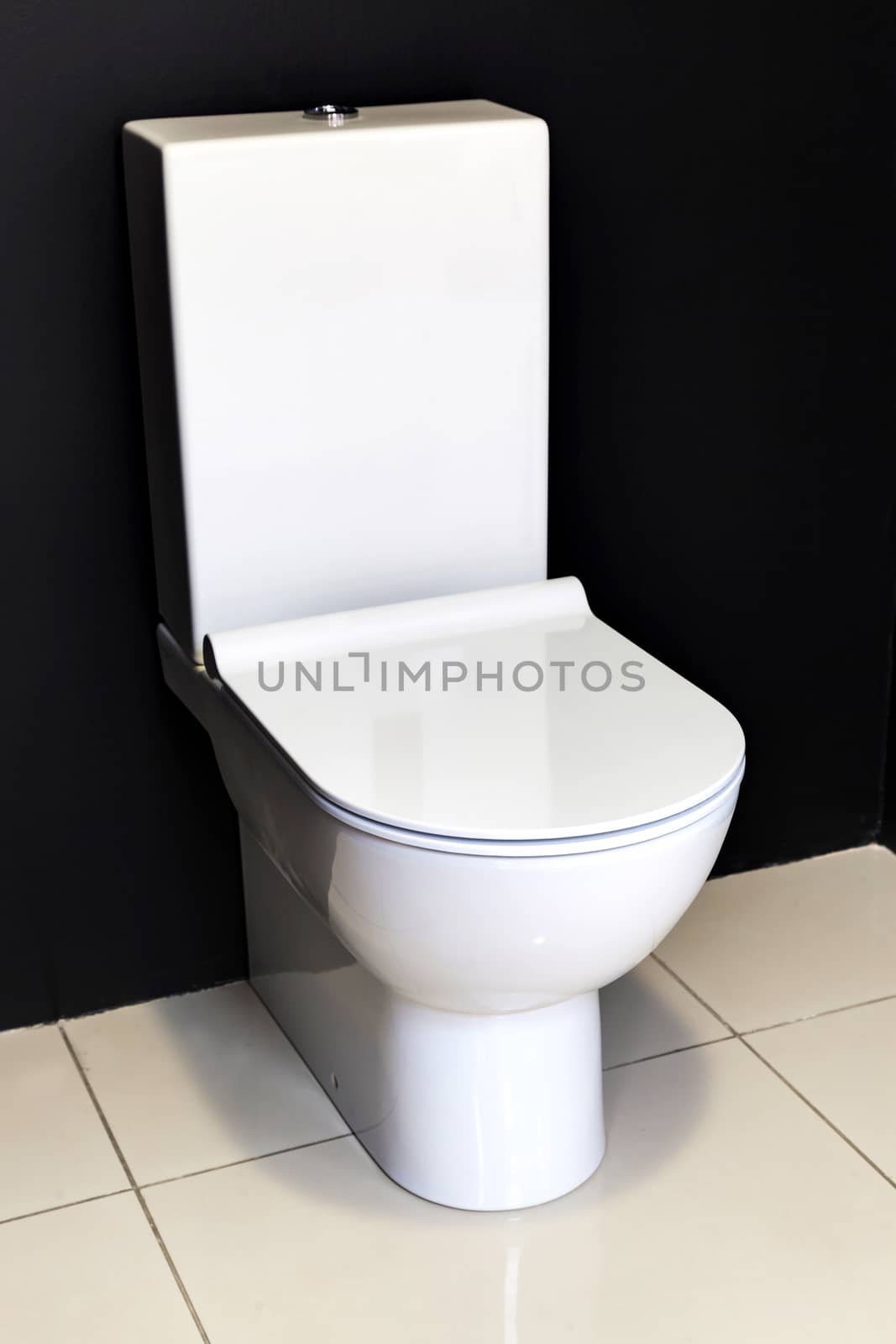 new modern white toilet bowl about a black wall