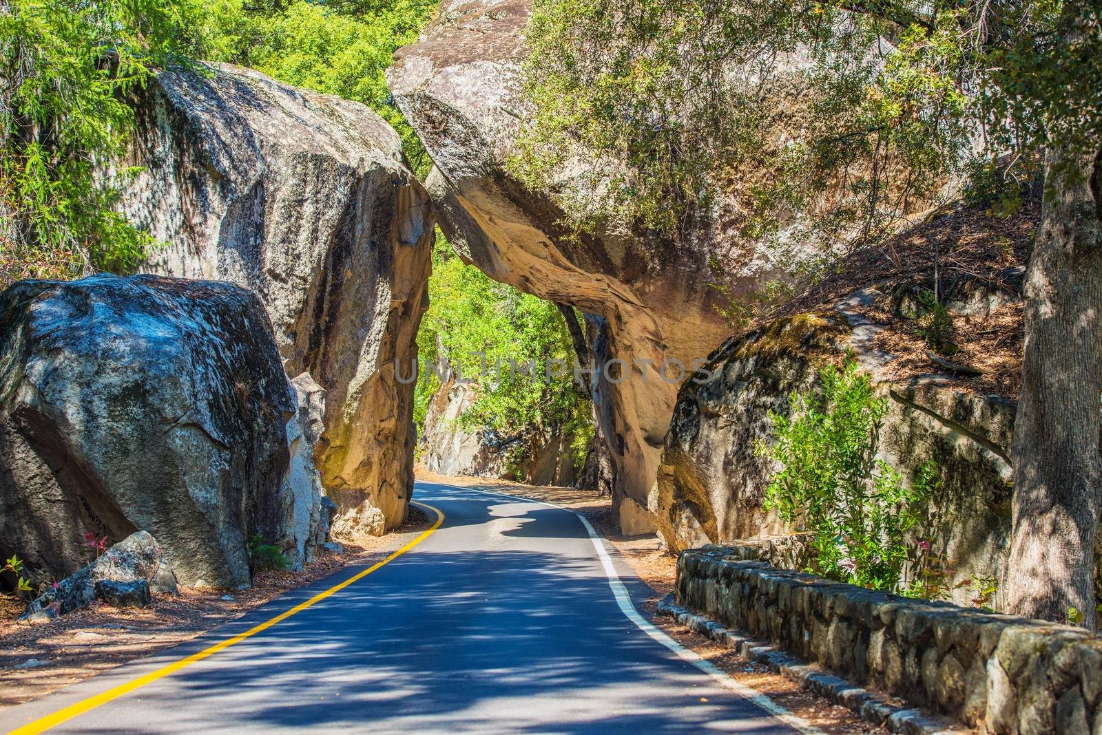 Natural Stone Bridge and the Road Through Sierra Nevada Mountains in California.